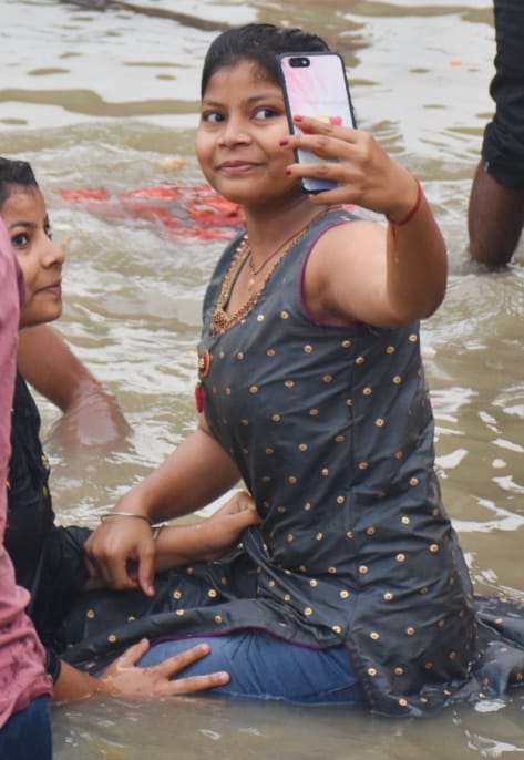 अयोध्या पतित पावनी सरयू में स्नान के बाद सेल्फी लेती युवती