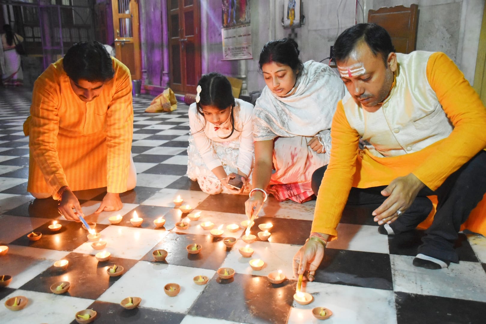 अयोध्या सुरसरि मंदिर में दीपक जलाते लोग अयोध्या सुरसरि मंदिर में दीपक जलाते लोग