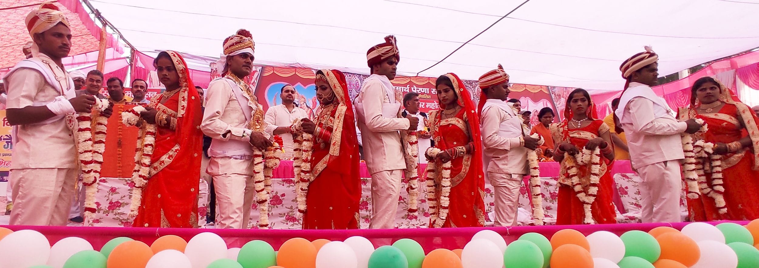 बुढ़वा के धर्म संस्कार महोत्सव में आयोजित सामूहिक विवाह में एक दूसरे को जयमाला पहनाने के लिए खड़?