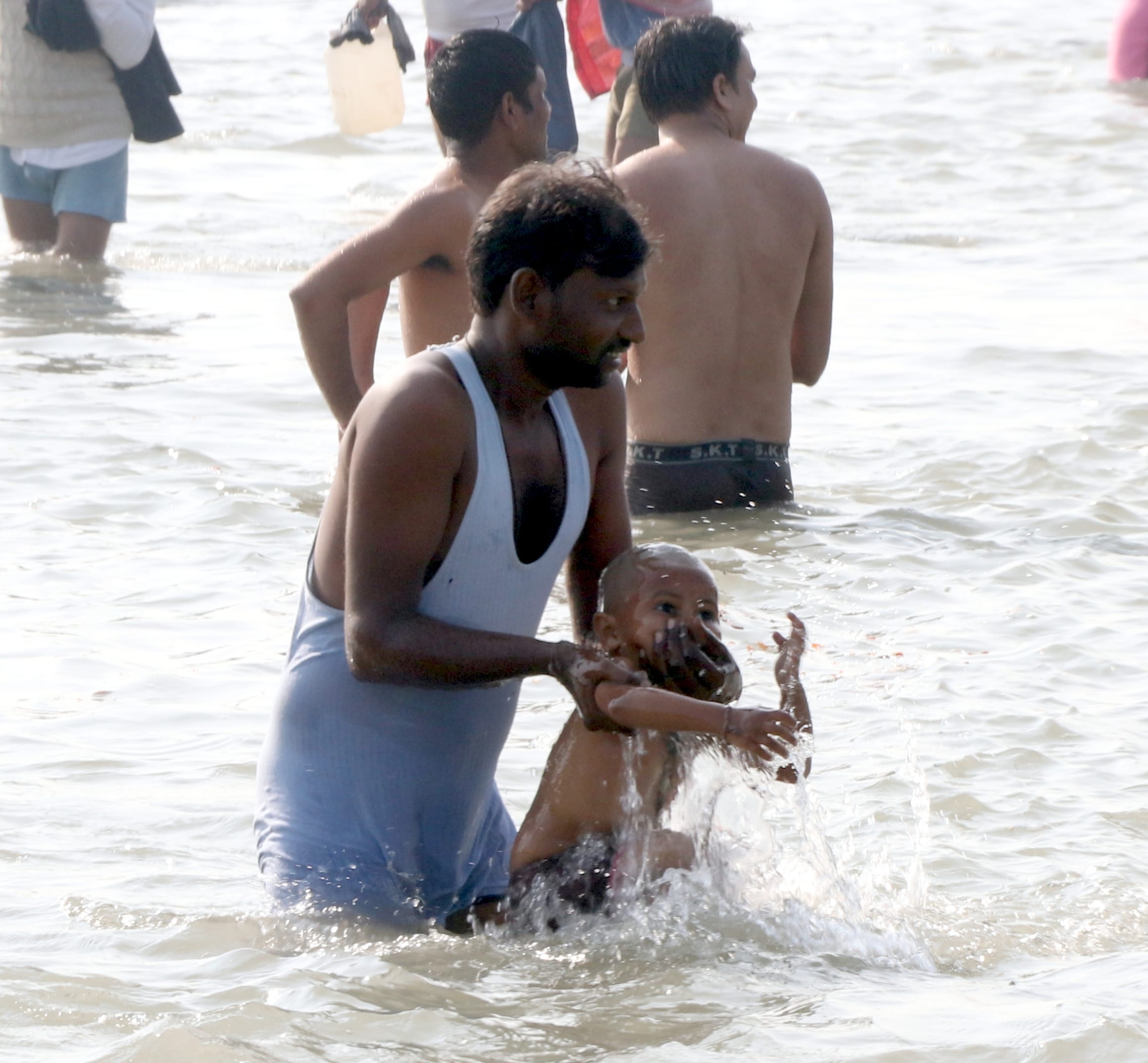 बिजनौर में विदुर कुटी के सामने गंगा स्नान पर गंगा में बच्चे को डुबकी लगवाता पिता। बिजनौर में विदुर कुटी के सामने गंगा स्नान पर गंगा में बच्चे को डुबकी लगवाता पिता।