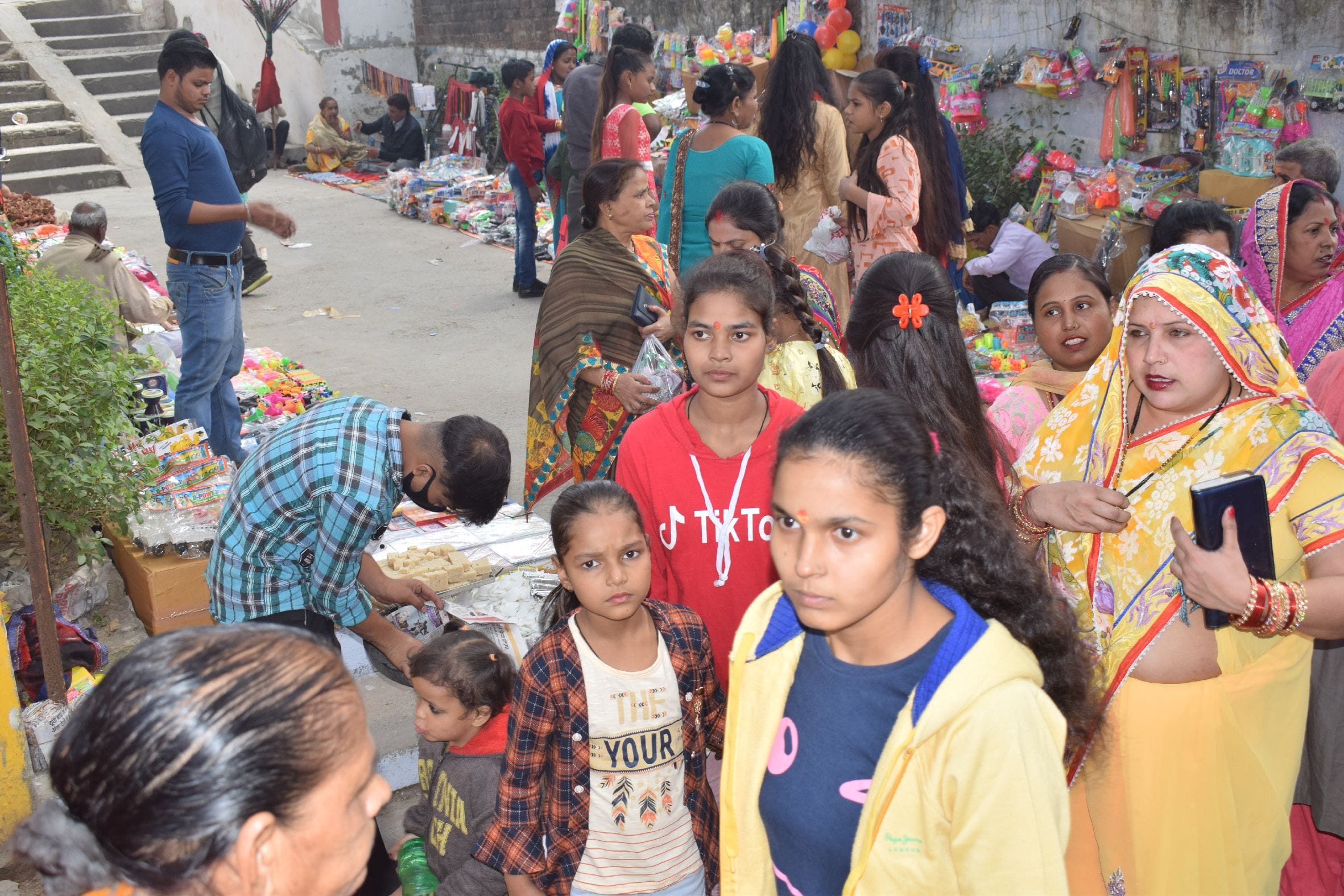 शाहजहांपुर में गंगा स्नान पर गर्रा नदी के बाहर लगा मेला में बच्चों के साथ खरीदारी करती महिलाएं । ?