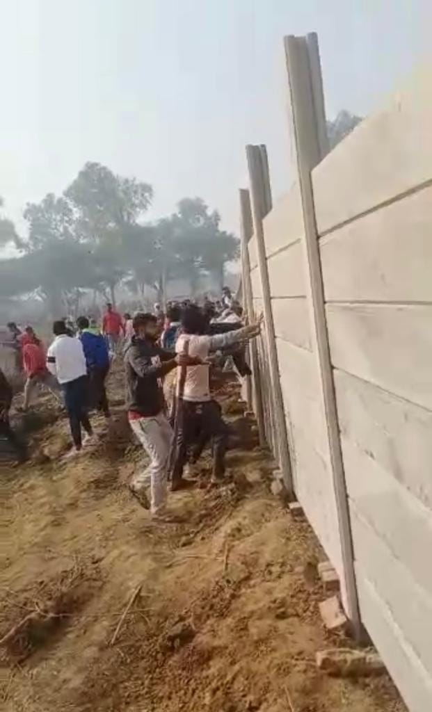 गाजियाबाद नगर निगम द्वारा बनायी गई चहारदीवारी को गिराते ग्रामीण।