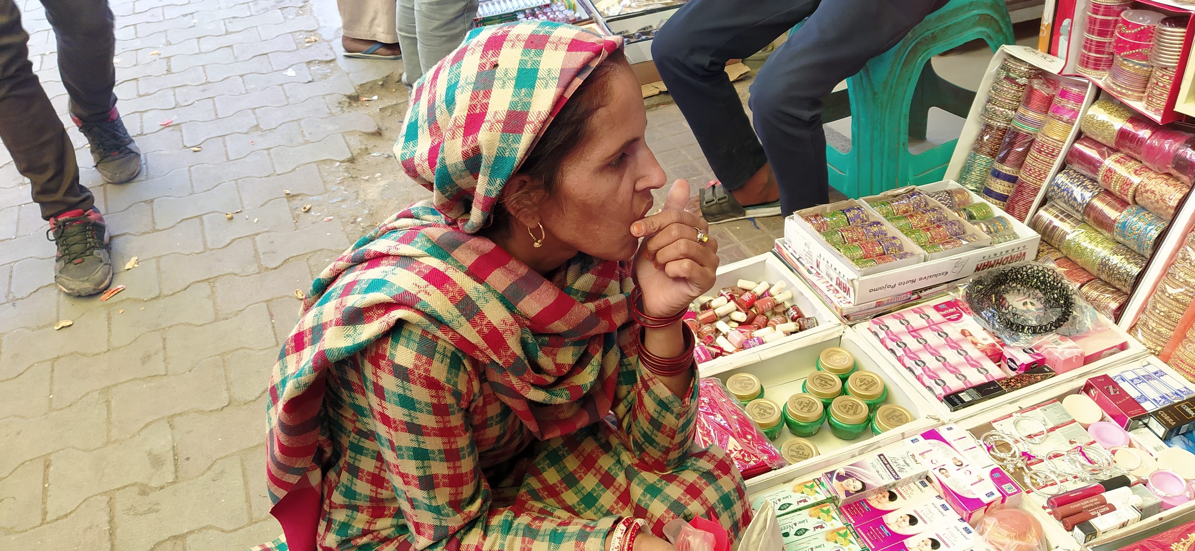 बाजार में एक फड़ी पर से सामान खरीदती हुई बिना मास्क पहने हुए महिला। बाजार में एक फड़ी पर से सामान खरीदती हुई बिना मास्क पहने हुए महिला।