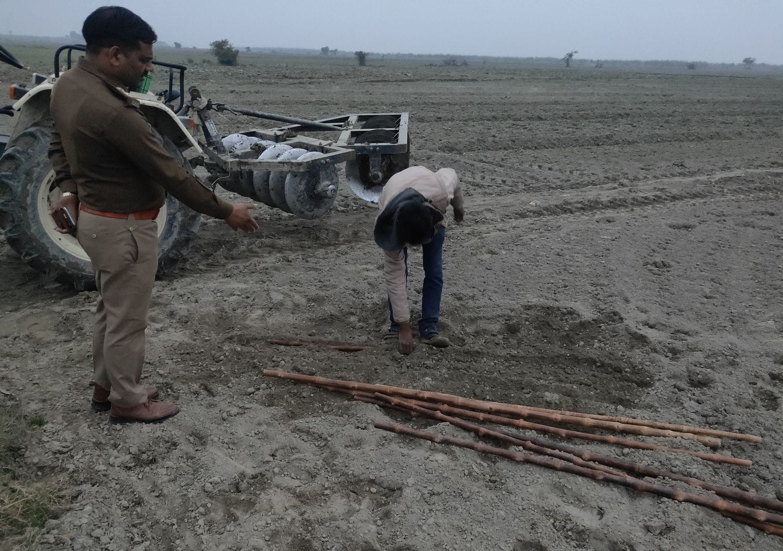 खेत में दबी लाठियों को निकलवाते थानाध्यक्ष दिनेश गौतम। संवाद खेत में दबी लाठियों को निकलवाते थानाध्यक्ष दिनेश गौतम। संवाद