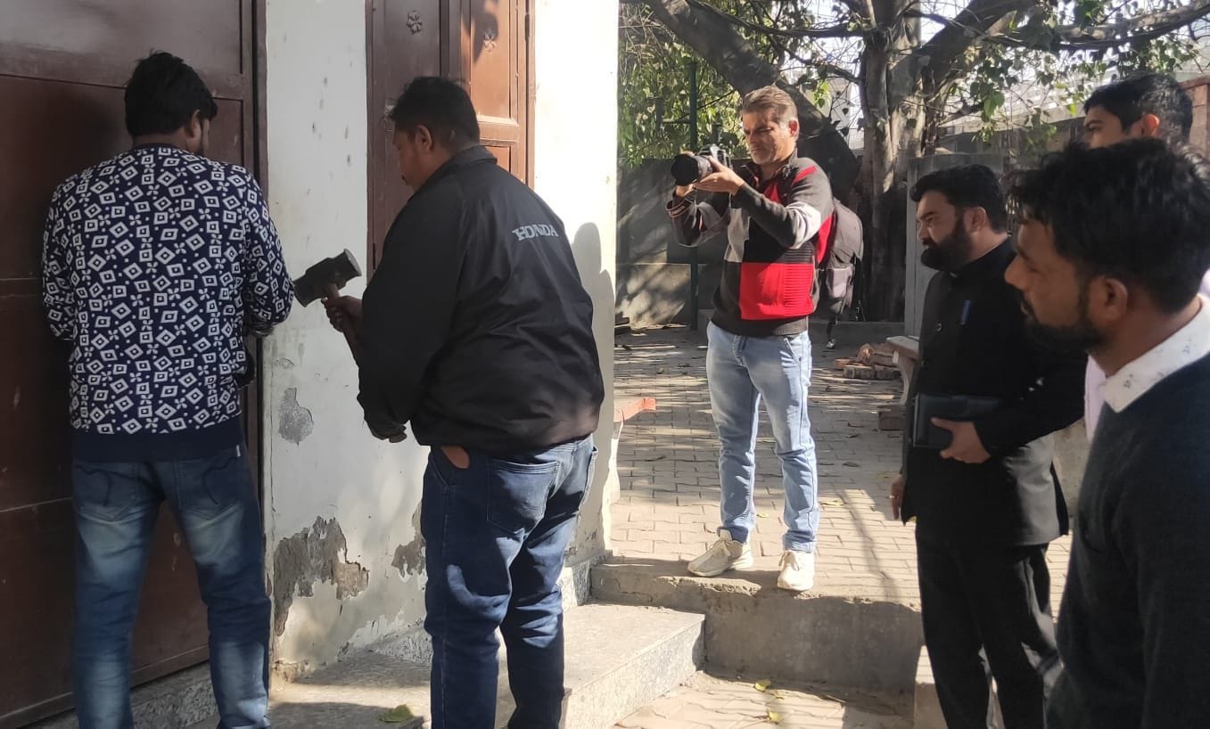पानीपत। सामुदायिक केंद्र का ताला तोड़ते हुए निगम कर्मी।