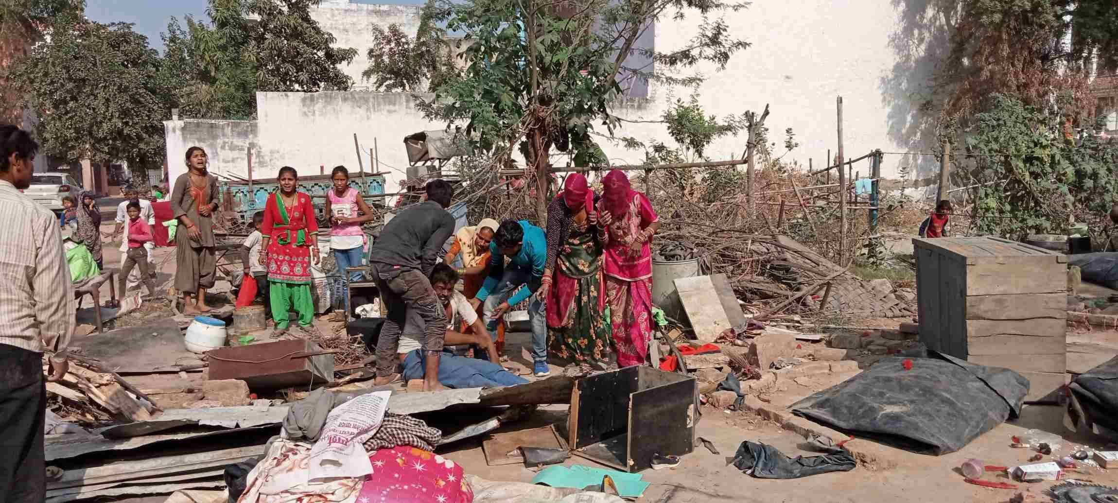 अपनी झुग्गी को टूटते देखकर बेहोश हुए व्यक्ति को पानी पिलाते परिजन। संवाद