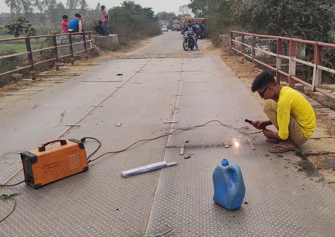 Artisan faisant la calvitie en tôle sur le pont de Bhainsi