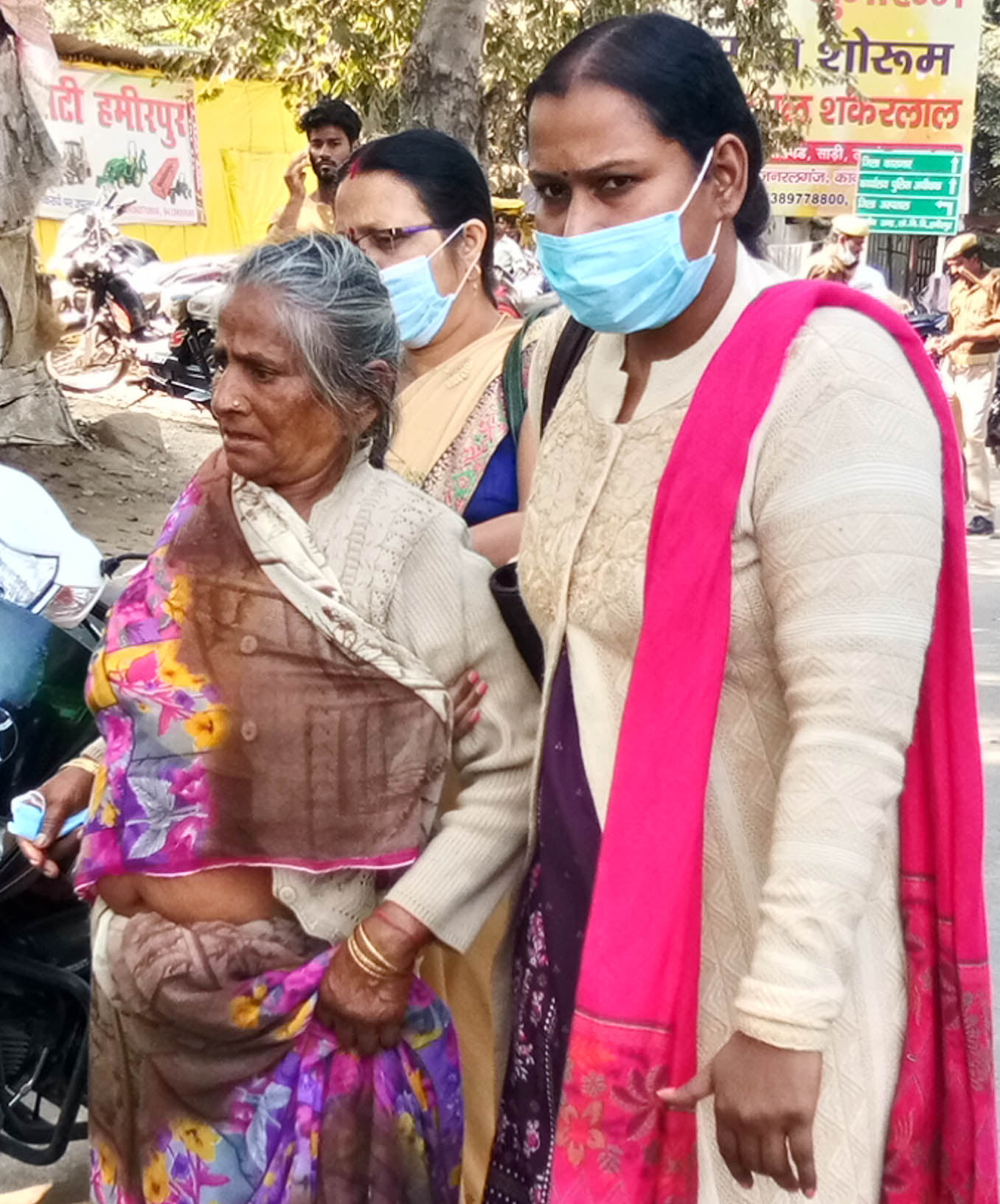 जिला अस्पताल से आई बीमार वृद्धा को सहारा देकर ले जाती महिलाएं।