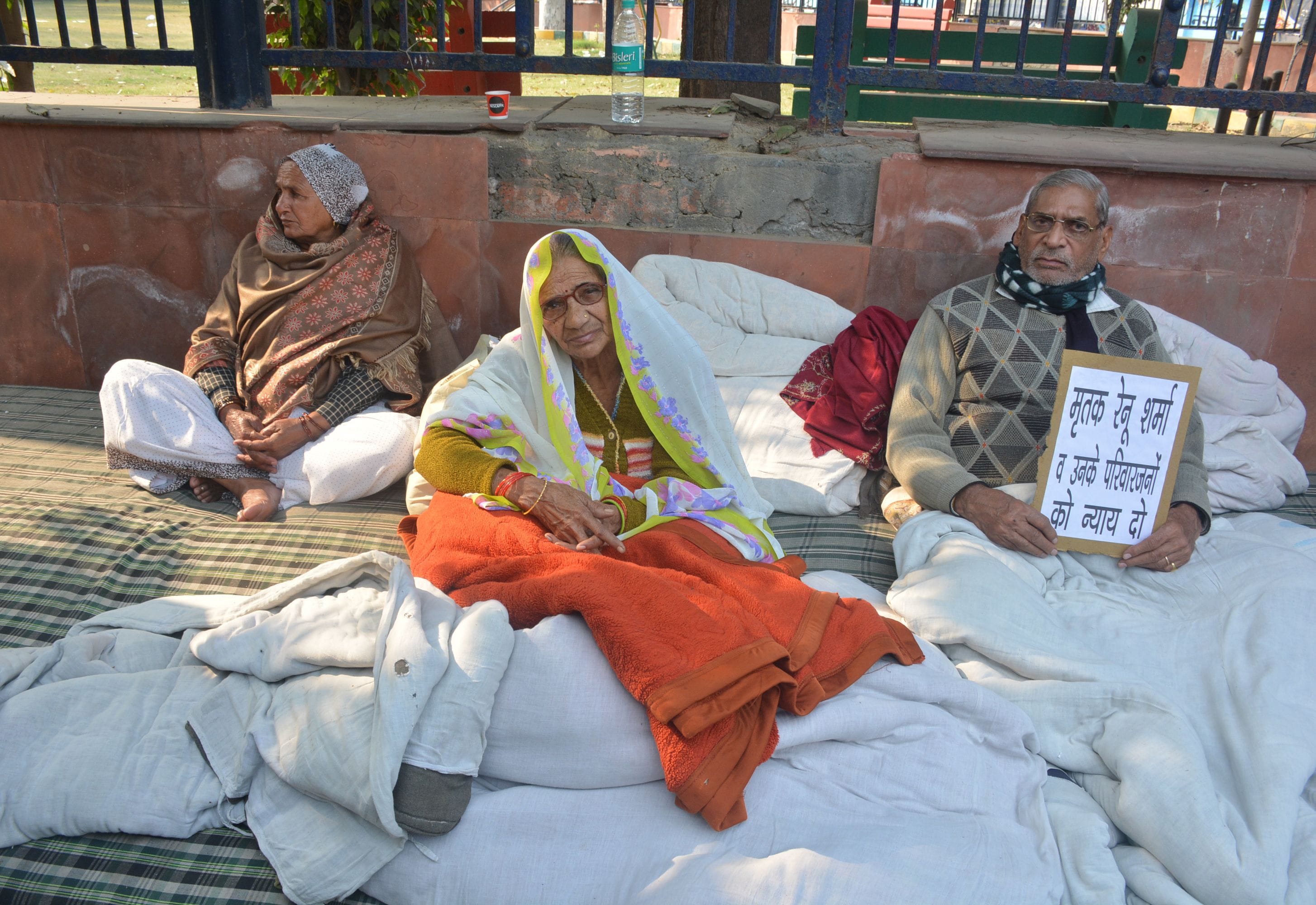 धरना पर बैठे शराब माफिया ऋषि शर्मा के परिजन।