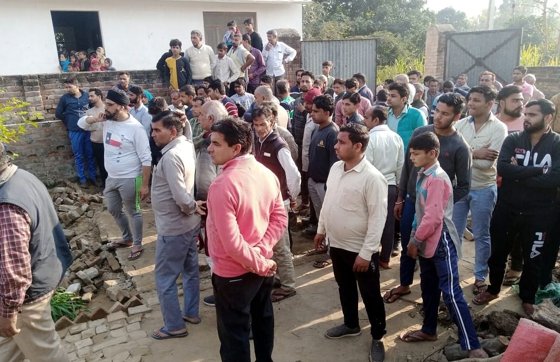 Une foule de personnes s'est rassemblée après la découverte du corps de la femme à Fayaznagar, Rajabpur.