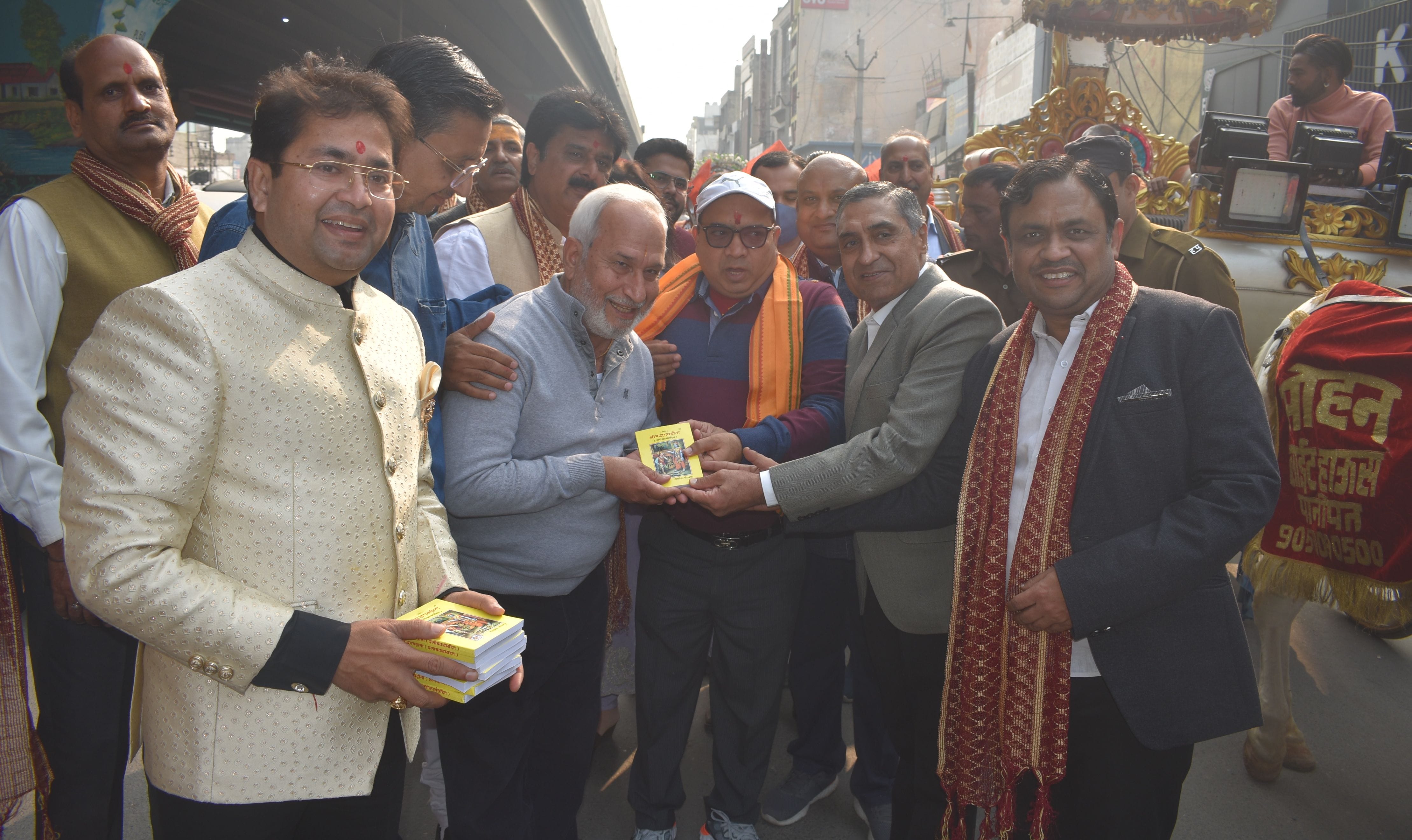 पानीपत। शोभायात्रा के दौरान लोगों को गीता बाटते हुए उपायुक्त व साथ में मौजूद हरिश बंसल व अन्य।