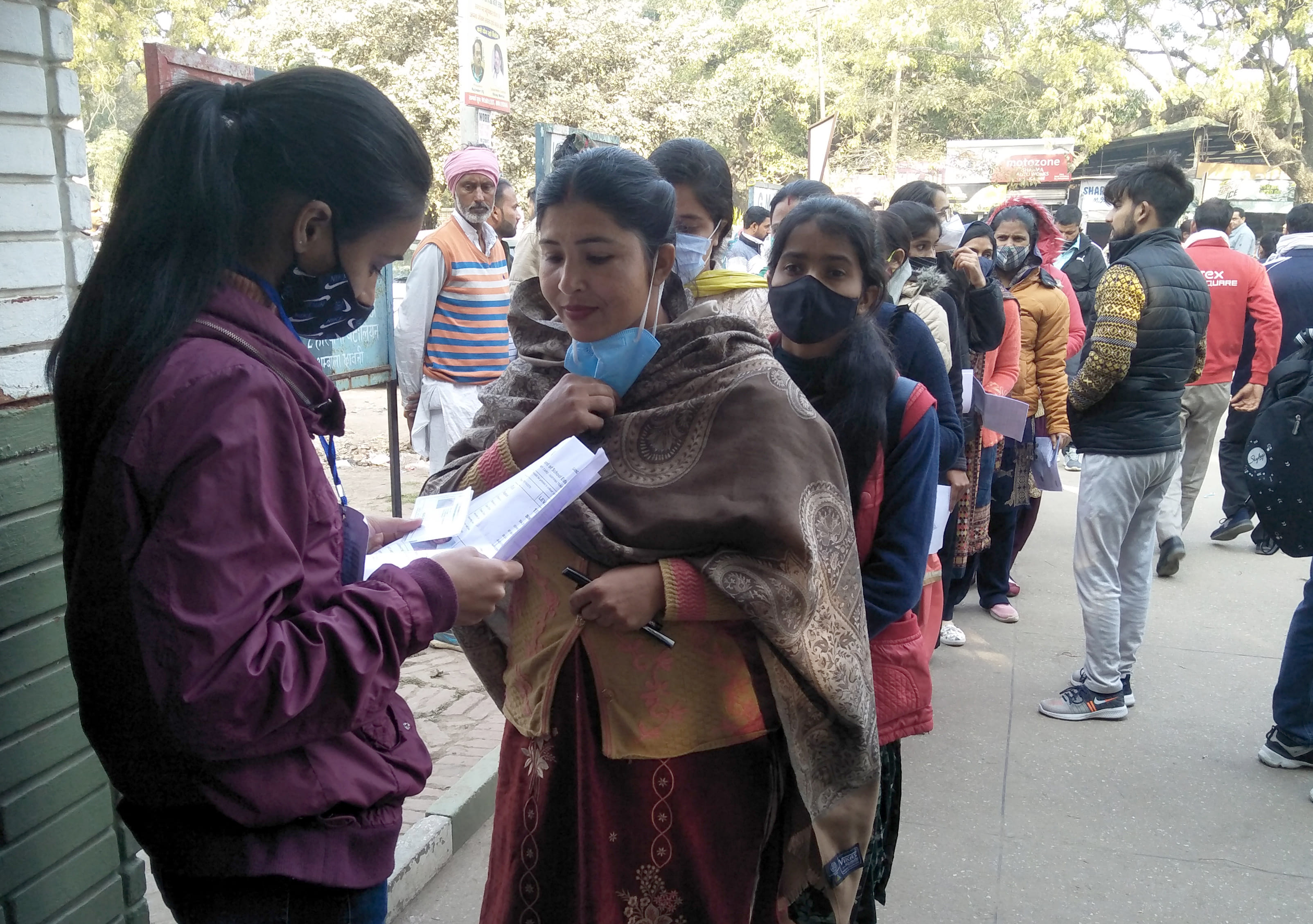 हरियाणा अध्यापक पात्रता परीक्षा से पहले परिक्षार्थियों के दस्तावेजों को चैक करती कर्मी।