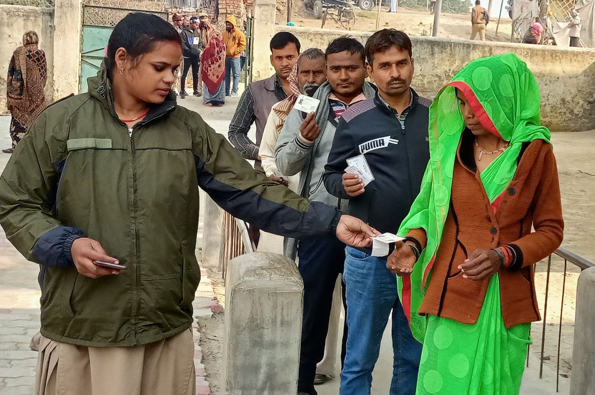 छिवली प्राथमिक विद्यालय में मतदाता का वोटरआईडी कार्ड चेक करती महिला पुलिस कर्मी। संवाद छिवली प्राथमिक विद्यालय में मतदाता का वोटरआईडी कार्ड चेक करती महिला पुलिस कर्मी। संवाद