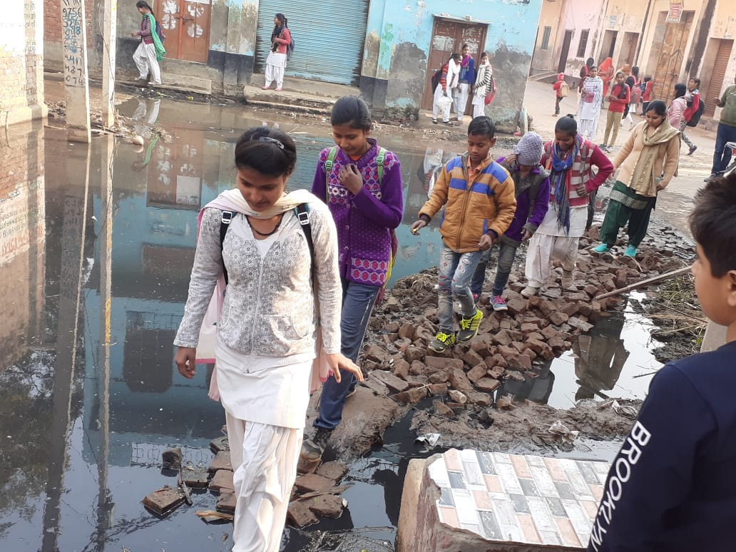 बड़ौत के मलकपुर गांव में दूषित पानी से भरी गली से होकर स्कूल जाते छात्र व छात्राएं। बड़ौत के मलकपुर गांव में दूषित पानी से भरी गली से होकर स्कूल जाते छात्र व छात्राएं।
