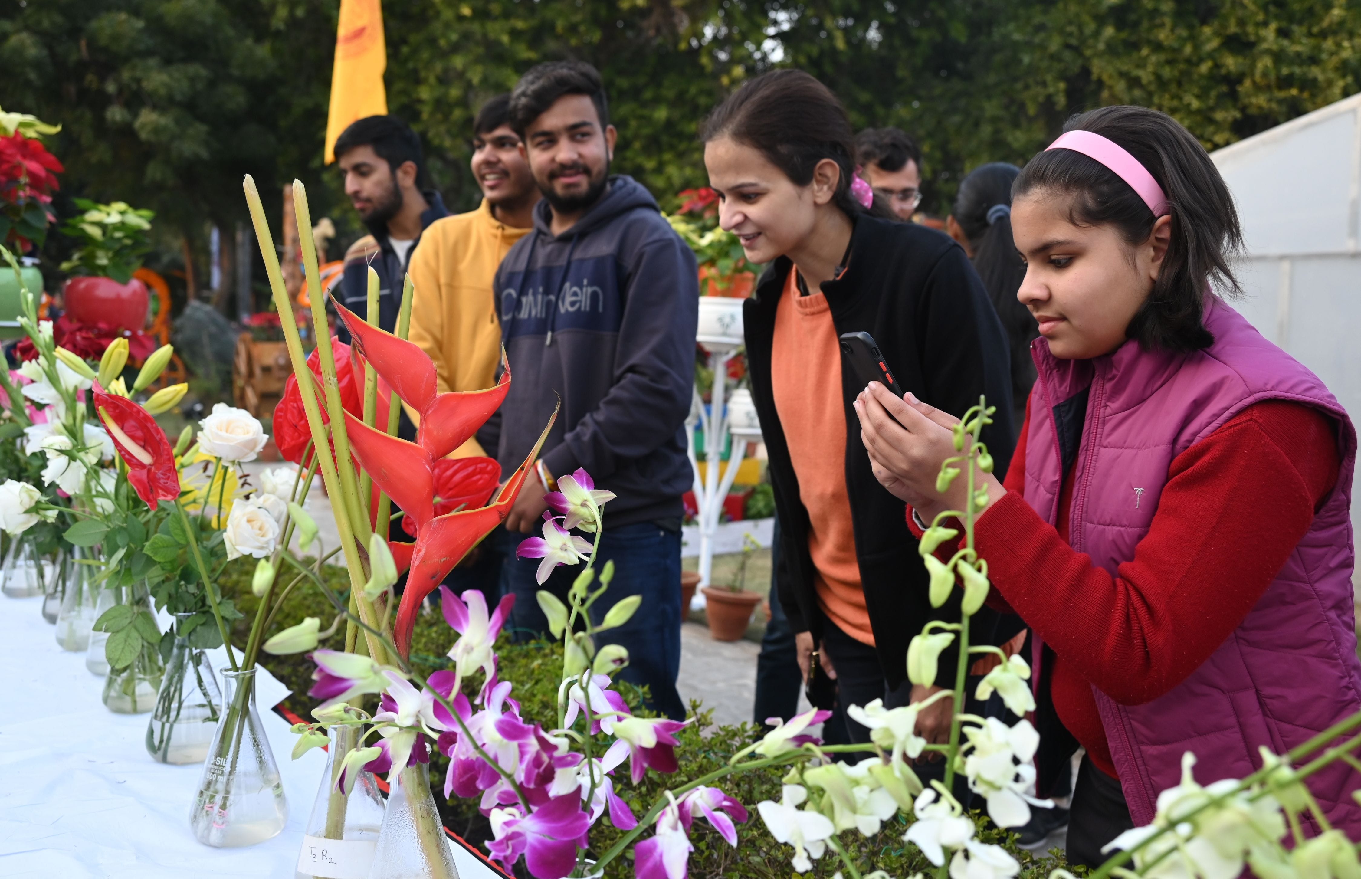 फ्लावर शो में एंथूरियम हेलीकोनिया आर्किड को देखते छात्र-छात्राएं । संवाद
