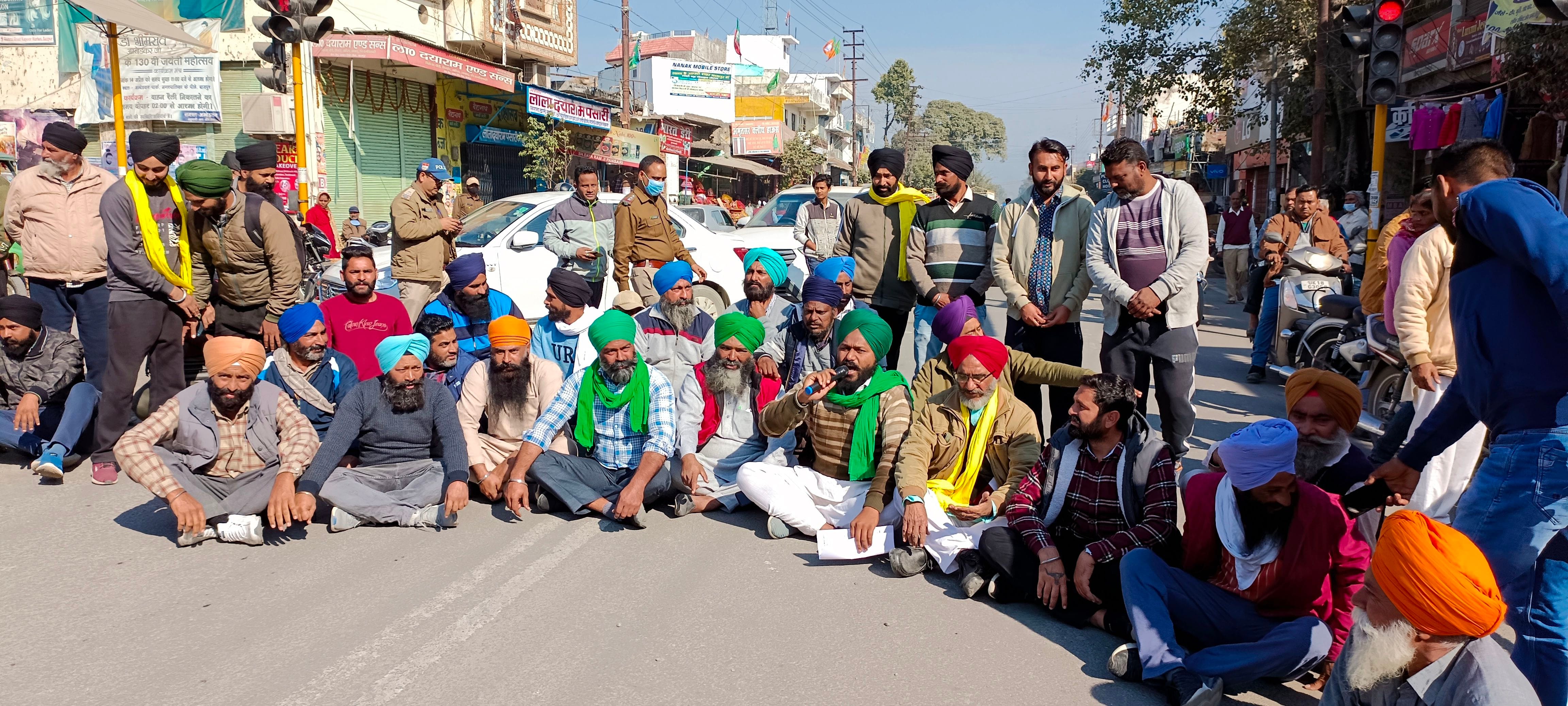 बाजपुर शहीद भगत सिंह चौक पर धरना देकर जाम लगाते किसान।
