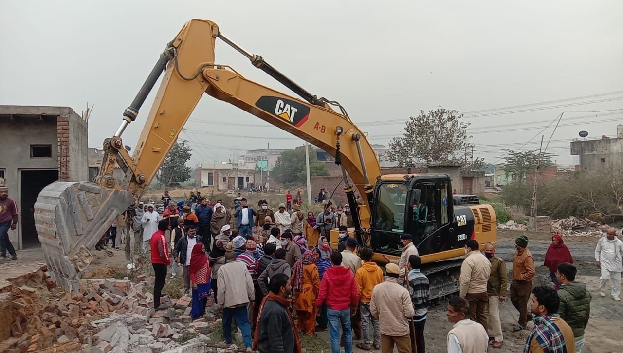 बहालगढ़ के पास कब्जा कार्रवाई के दौरान मकान को तोड़ती पोकलेन मशीन। संवाद