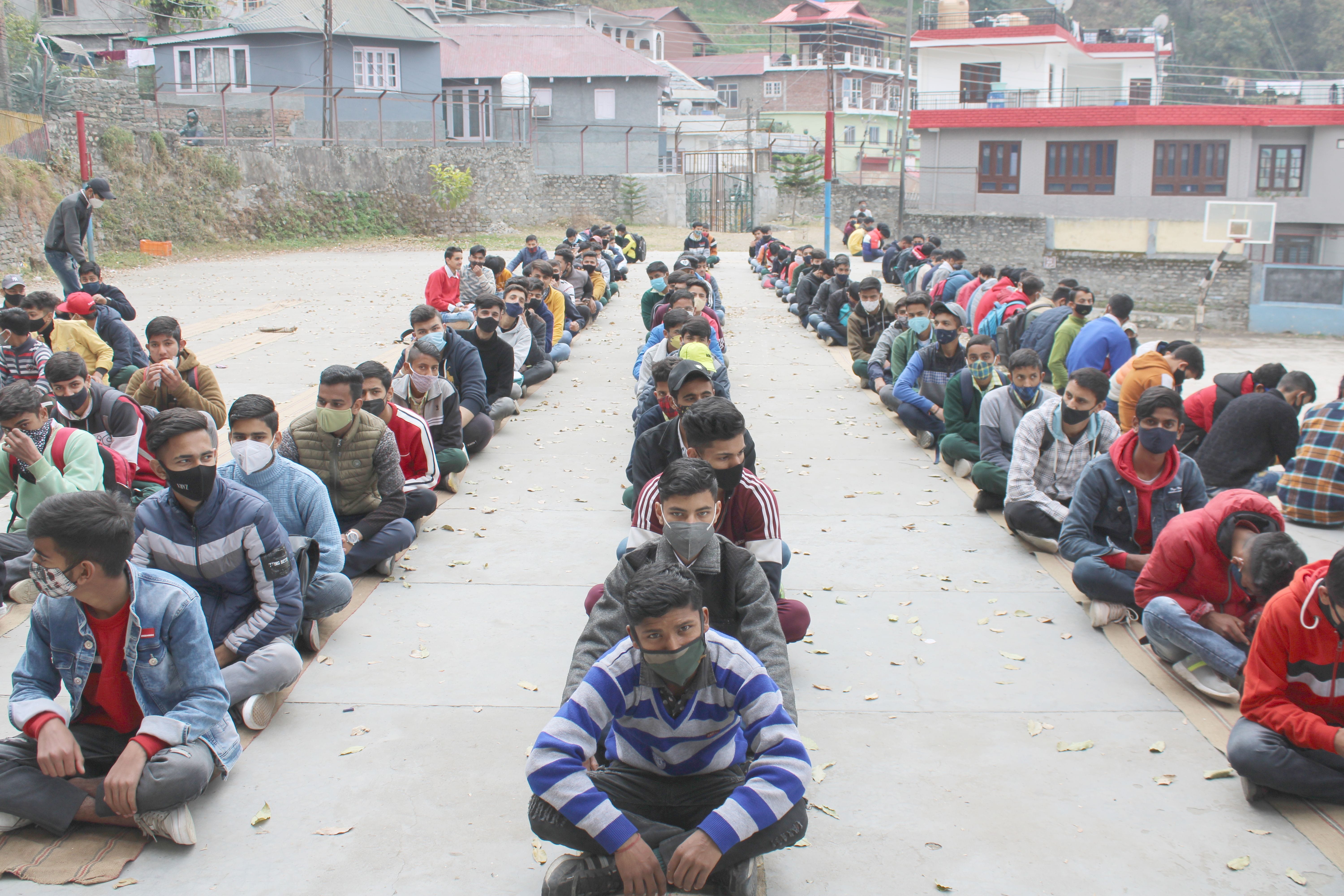 बॉय स्कूल चंबा में टीकाकरण के लिये पंजीकरण करवाने से पहलें ग्राउंड में बैठ अपनी बारी का इंतजार कर बॉय स्कूल चंबा में टीकाकरण के लिये पंजीकरण करवाने से पहलें ग्राउंड में बैठ अपनी बारी का इंतजार कर