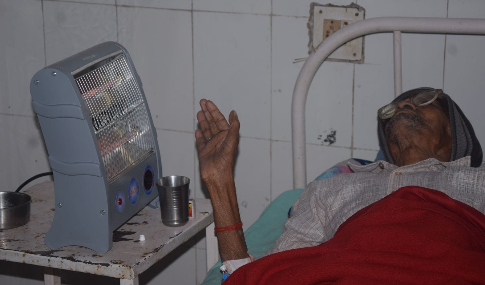 घर से लाए हीटर से तापते लोहिया अस्पताल के वार्ड में भर्ती श्रीपाल। संवाद