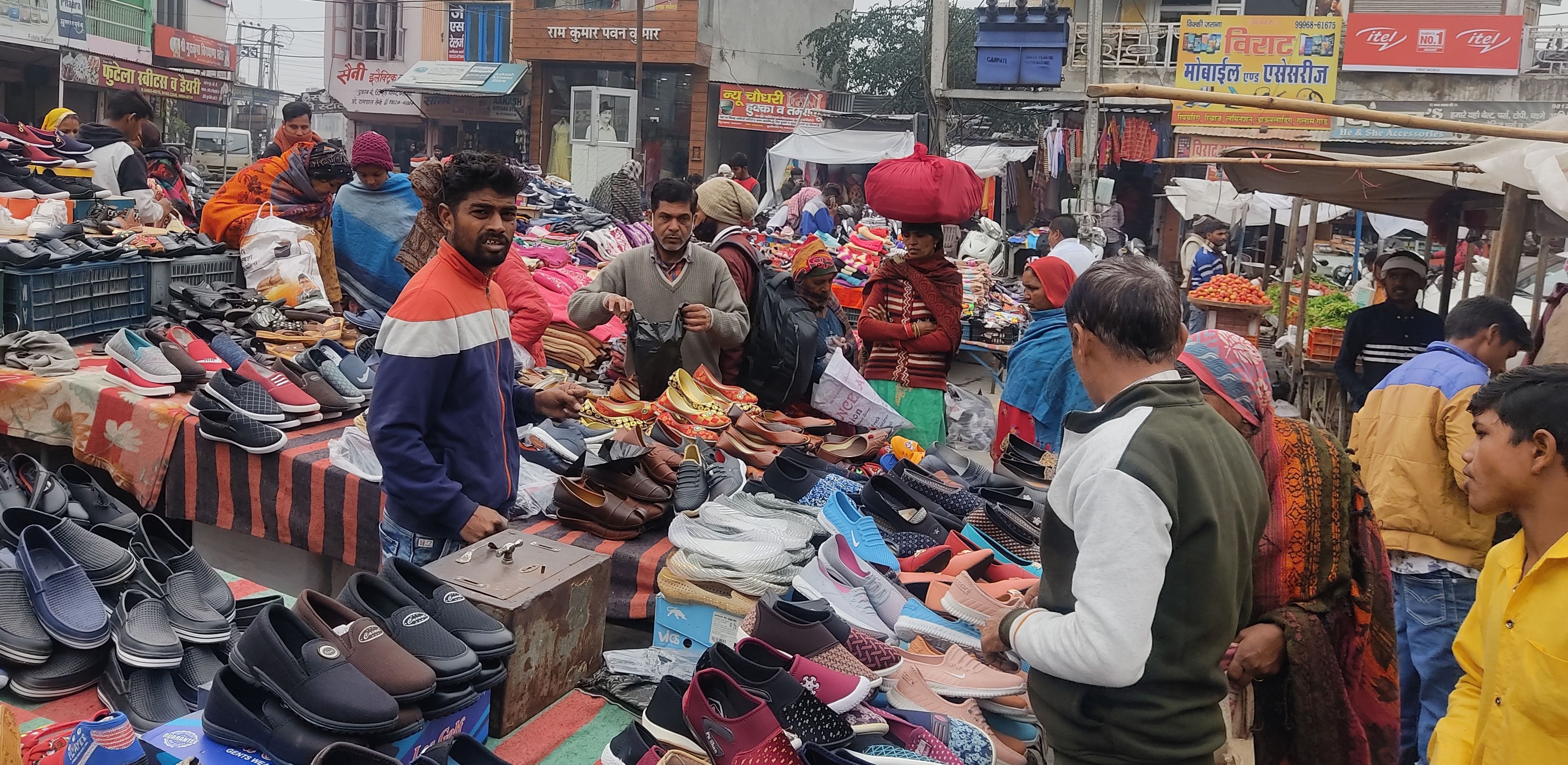 हंस मार्केट में एक स्टाल पर बिना मास्क विक्रेता व खरीदार।