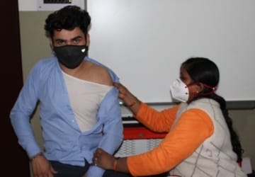 शामली स्कॉटिश स्कूल में टीका लगवाता छात्र।
