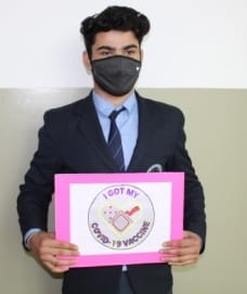 शामली स्कॉटिश स्कूल में  टीका करण के प्रति जागरूक करता छात्र।