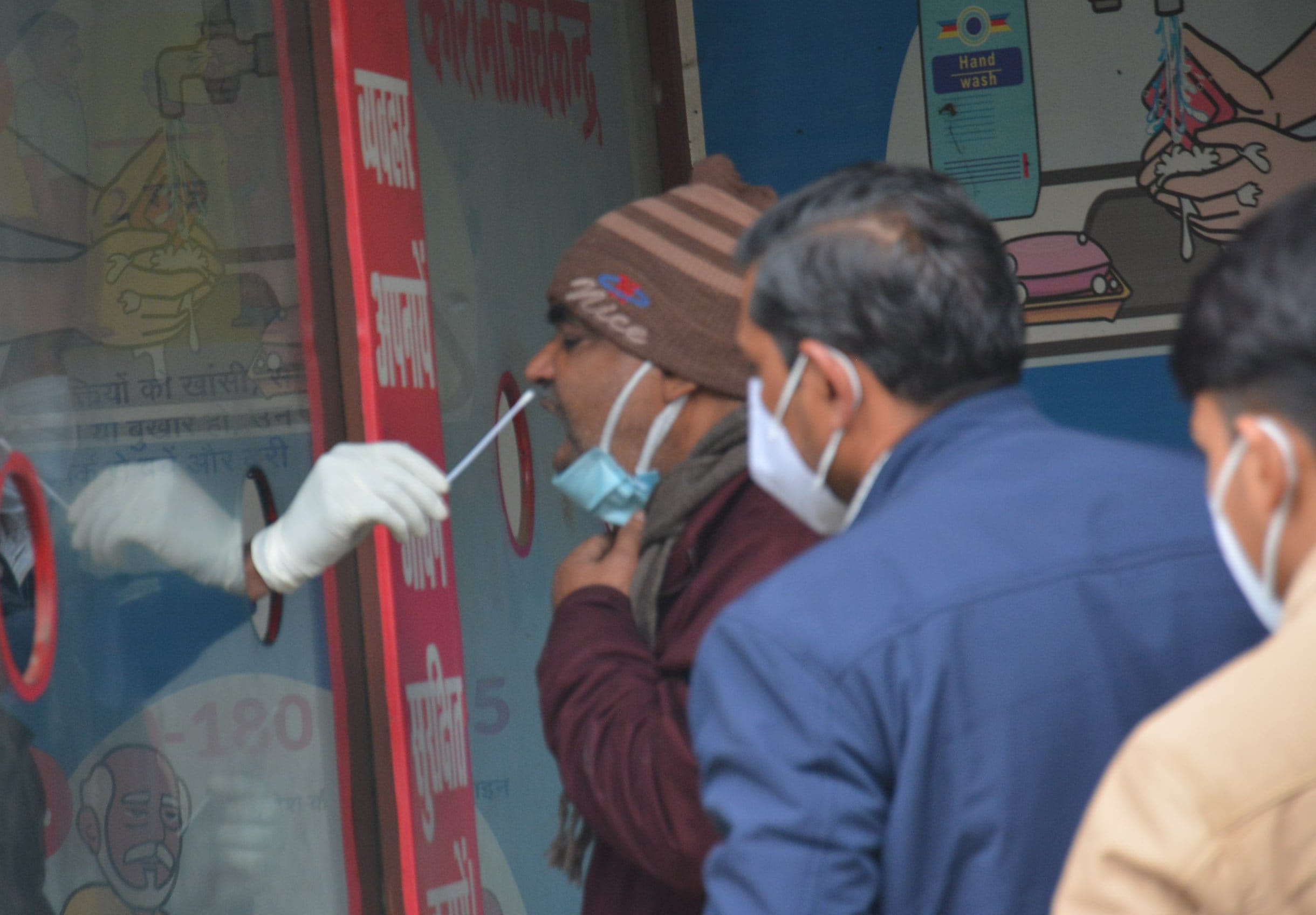कॉरोना जांच केद्र पर सैम्पल लेता स्वास्थकर्मी।