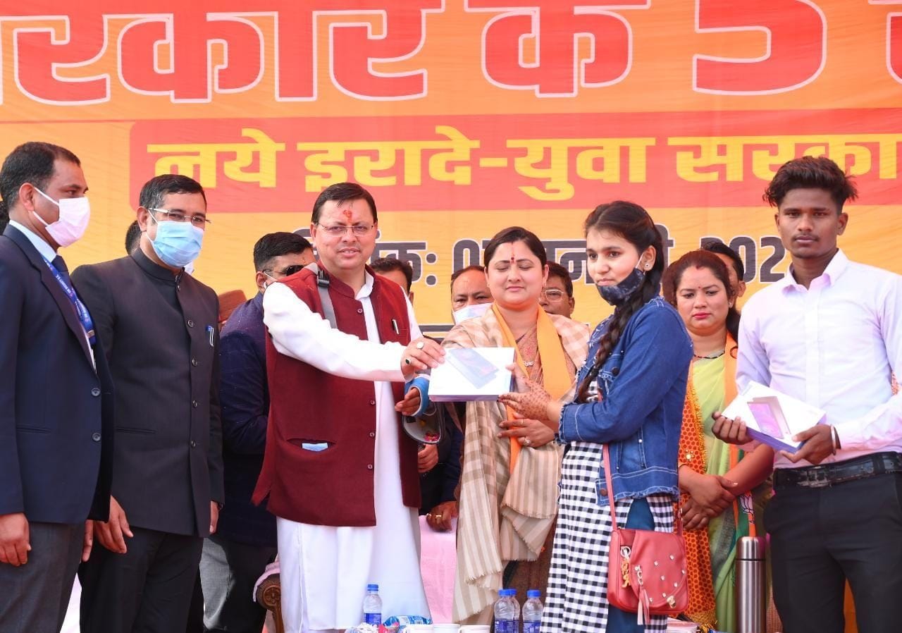 खटीमा में चटिया फार्म में आयोजित कार्यक्रम में मेधावी छात्रा को टैबलेट प्रदान करते सीएम धामी। स?