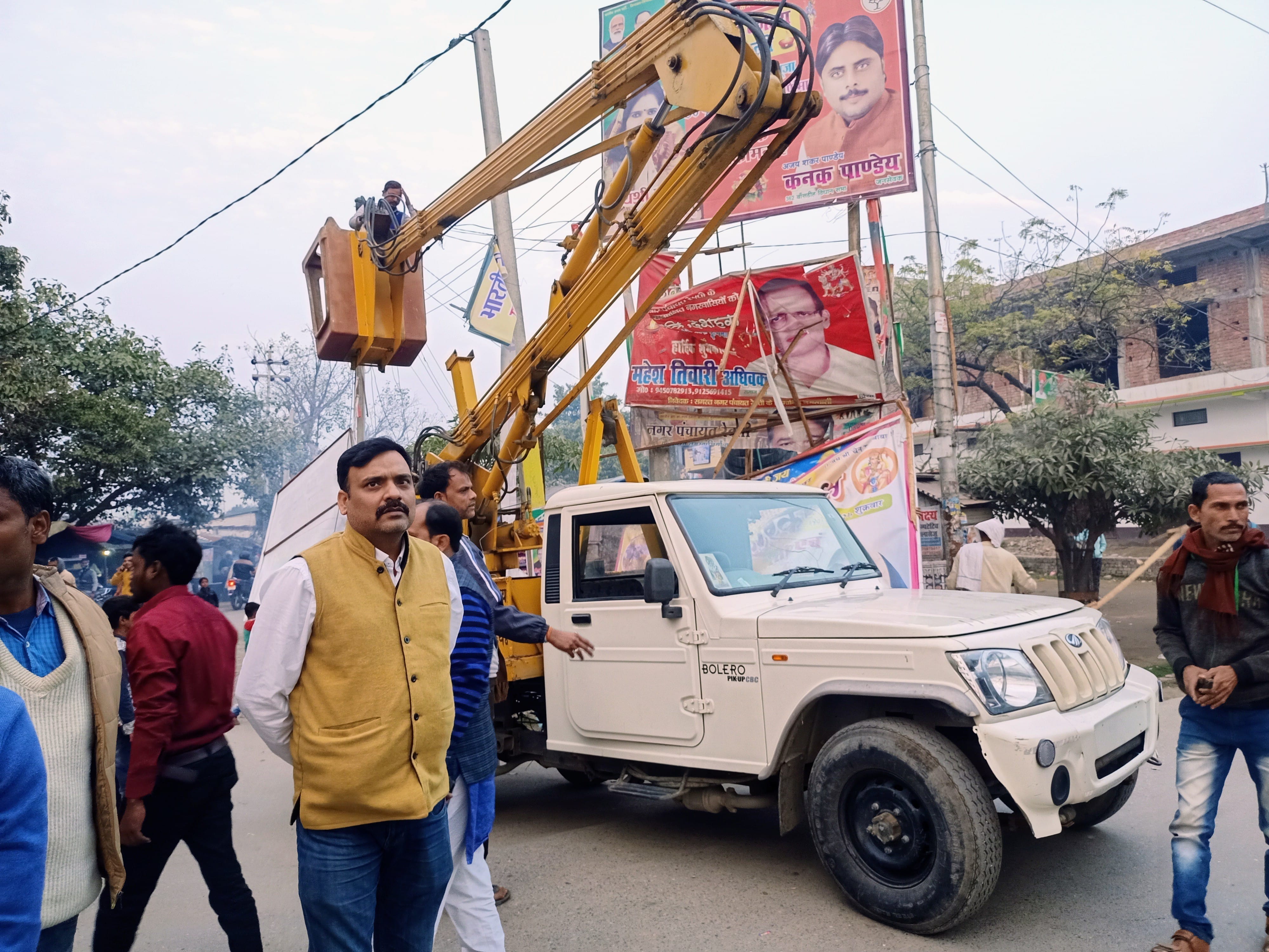 रेवती कस्बा में लगे होर्डिंग को हटवाते नगर पंचायत के कर्मचारी। रेवती कस्बा में लगे होर्डिंग को हटवाते नगर पंचायत के कर्मचारी।