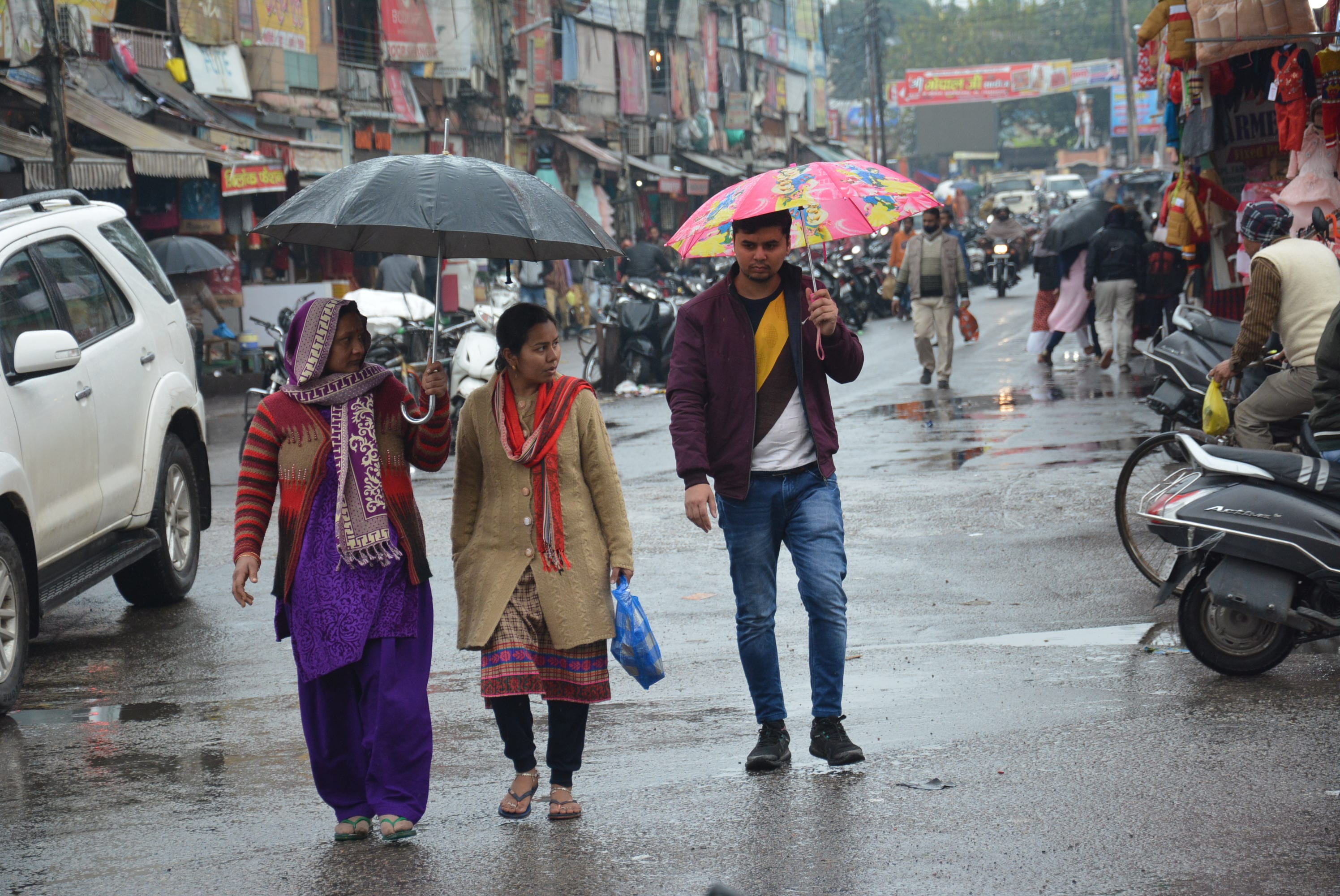 मुजफ्फरनगर में बारिश में छाता लेकर शिव चौक से गुजरते राहगीर। मुजफ्फरनगर में बारिश में छाता लेकर शिव चौक से गुजरते राहगीर।
