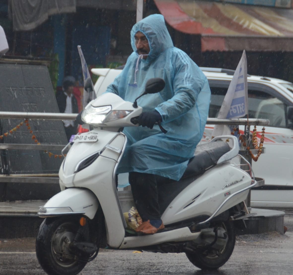 बागपत के राष्ट्र वंदना चौक पर बारिश के बीच गुजरता व्यक्ति बागपत के राष्ट्र वंदना चौक पर बारिश के बीच गुजरता व्यक्ति