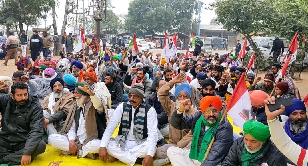 फतेहाबाद में लघु सचिवालय के गेट के बाहर धरने पर बैठे किसान।