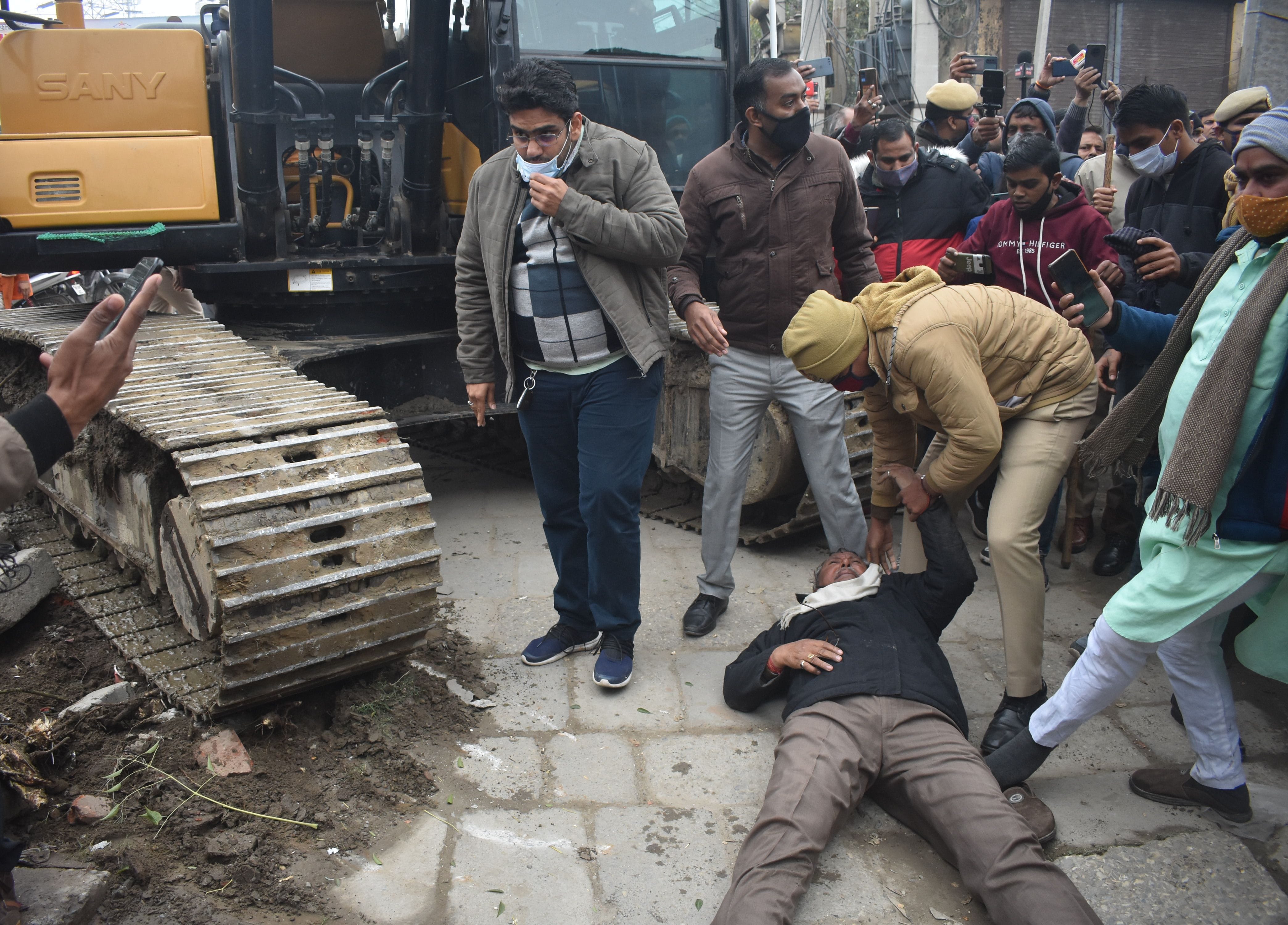 पानीपत। जब मंदिर को तोड़ा गया तो जेसीबी के आगे लेटा स्थानिय बुजुर्ग उसको उठाते हुए पुलिसकर्मी। पानीपत। जब मंदिर को तोड़ा गया तो जेसीबी के आगे लेटा स्थानिय बुजुर्ग उसको उठाते हुए पुलिसकर्मी।