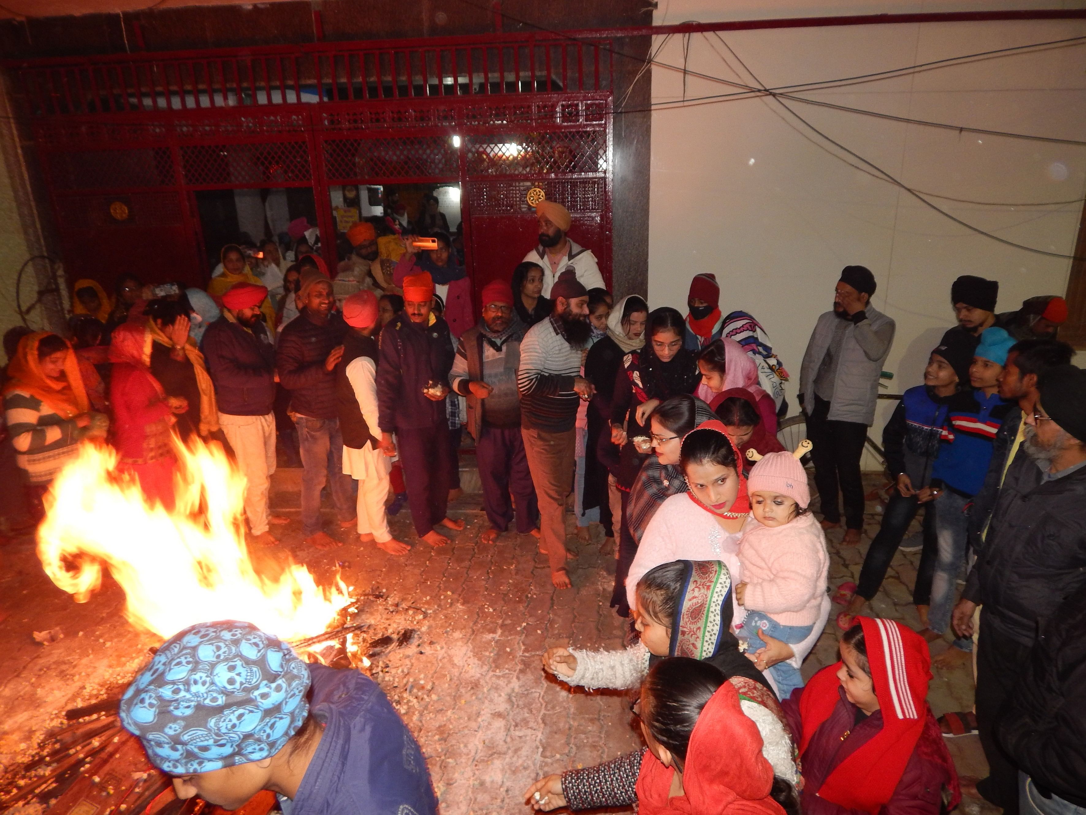 Orang-orang dari komunitas Sikh merayakan festival Lohri di depan Gurudwara kota.