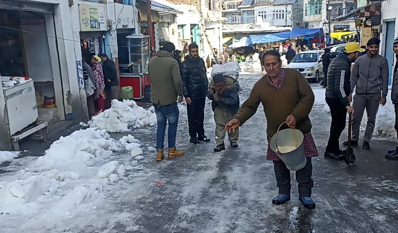 Employés de la municipalité de Bhadarwa travaillant à faire fondre la neige en ajoutant du sel Employés de la municipalité de Bhadarwa travaillant à faire fondre la neige en ajoutant du sel