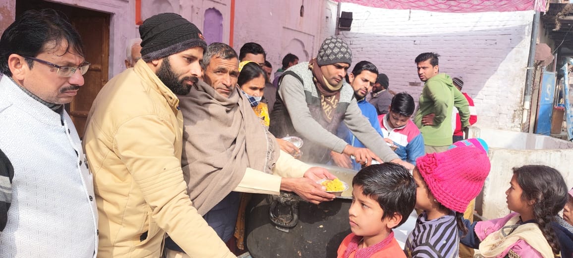 सुलतानपुर में मकर संक्रांति पर प्रसाद वितरित करते लोग