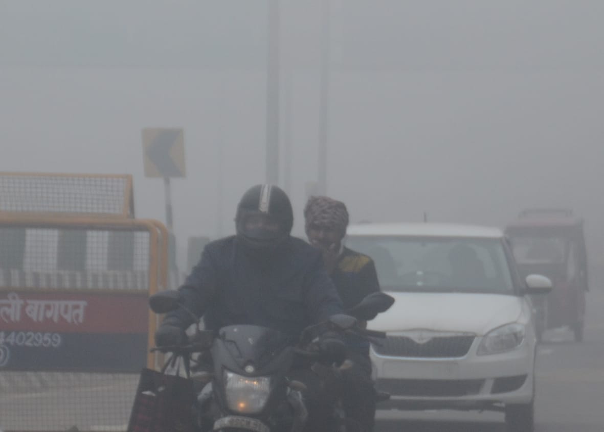 बागपत में दिल्ली-सहारनपुर नेशनल हाईवे पर कोहरे के बीच गुजरते वाहन चालक