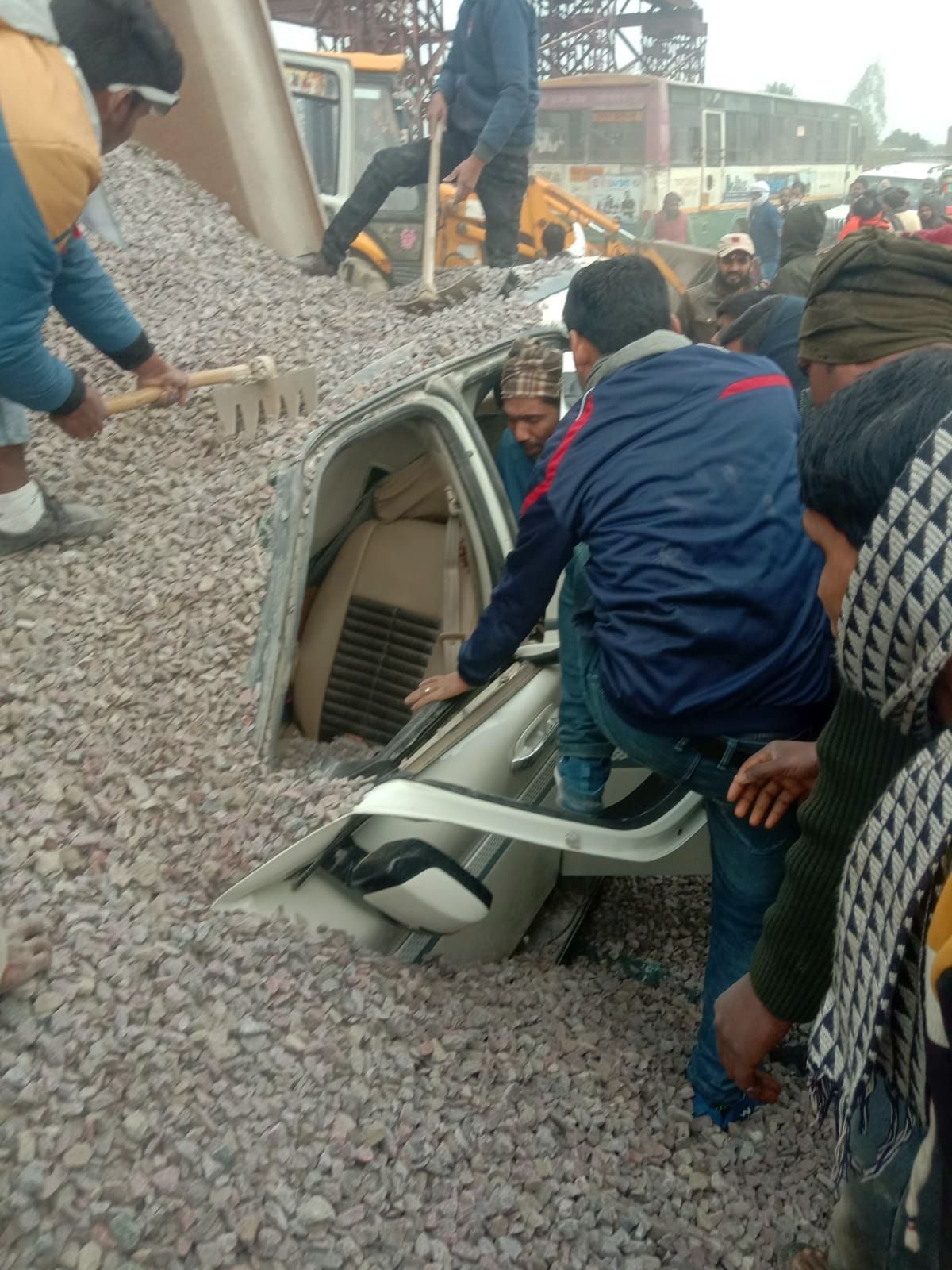 हाईवे पर गिटटी लदे डंपर के कार पर गिरने के बाद कार में फंसे यात्रियों को निकालते स्थानीय लोग व पु? हाईवे पर गिटटी लदे डंपर के कार पर गिरने के बाद कार में फंसे यात्रियों को निकालते स्थानीय लोग व पु?