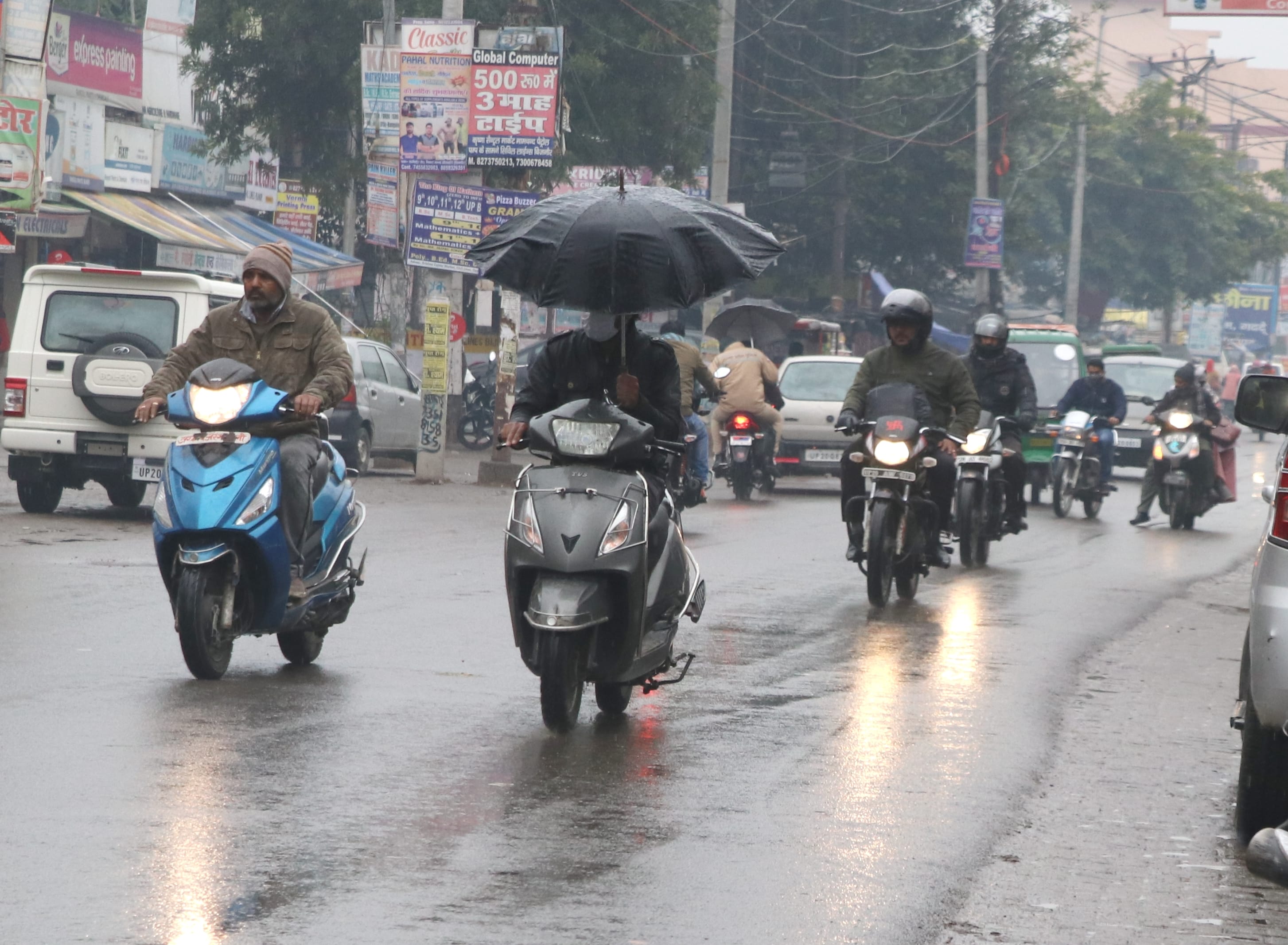 बिजनौर में बारिश में जाते लोग।