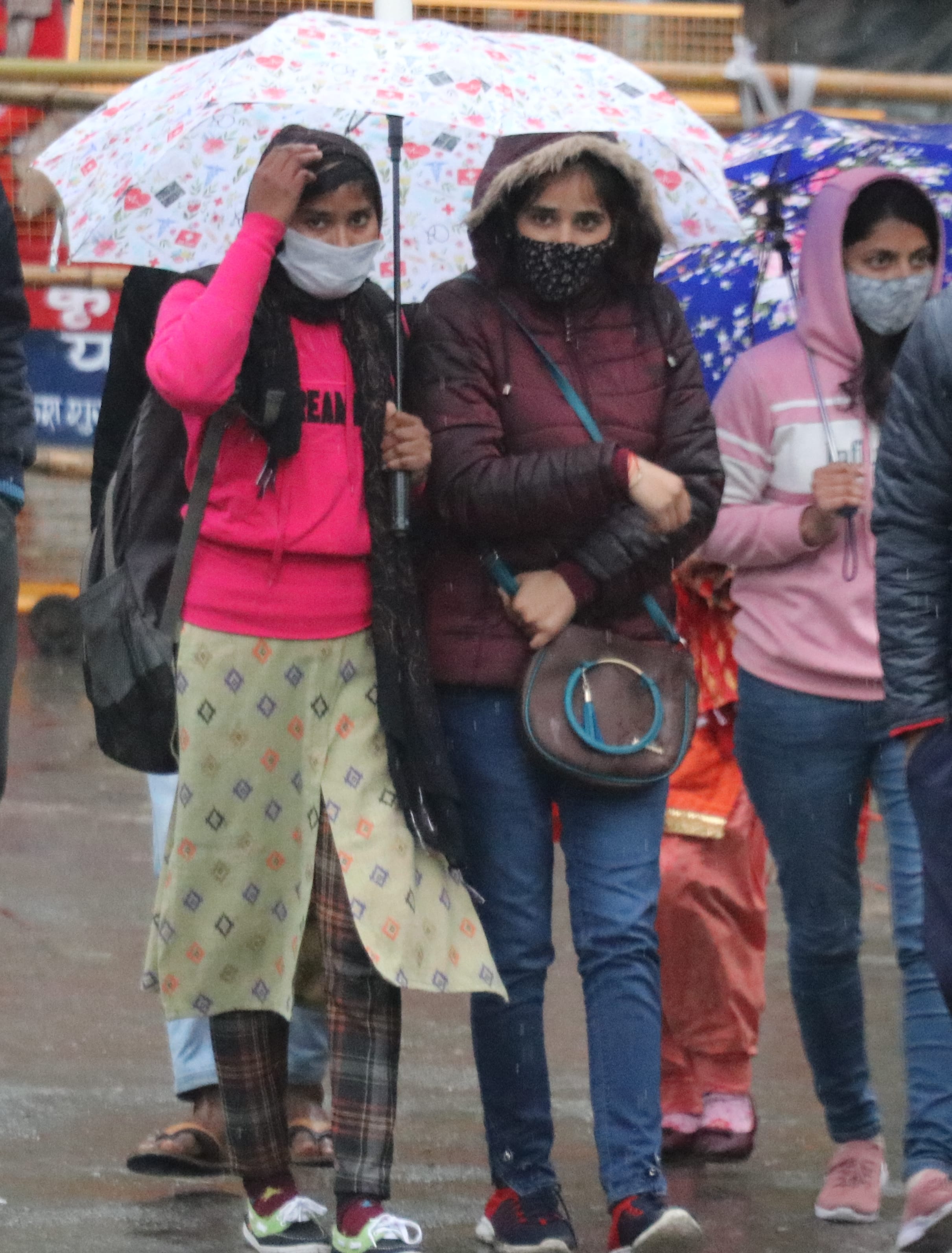 बिजनौर में टीईटी की परीक्षा देकर बाहर आने के बाद छाता लगाकर जाती परीक्षार्थी।