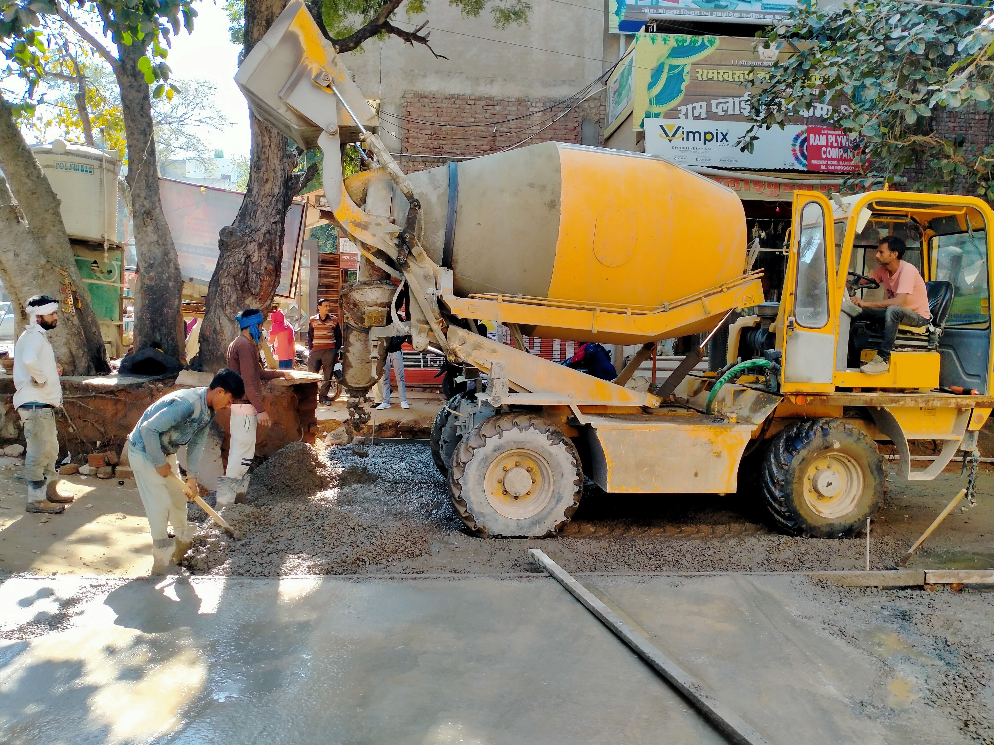 अनाज मंडी सड़क के निर्माण के लिए सामग्री तैयार करती मशीन। संवाद