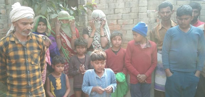 घर के आंगन में खड़े गांव के लोग। संवाद