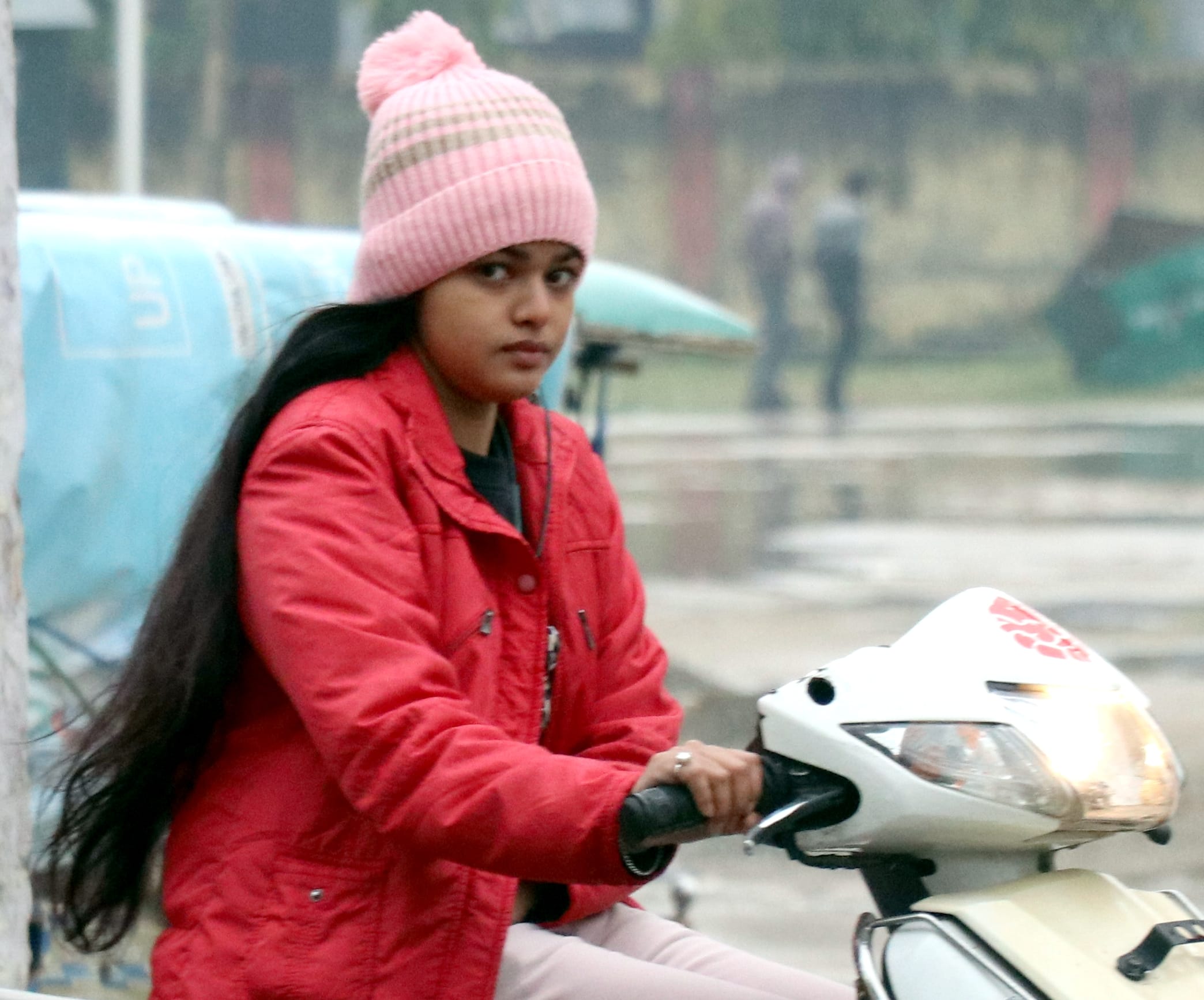 बिजनौर में बारिश में जाती युवती।