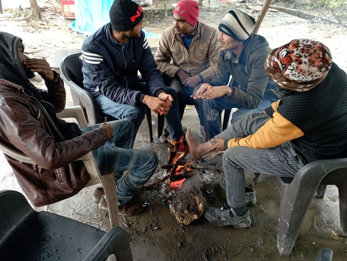रुद्रपुर में ठंड से बचने के लिए आग तापते निर्माण मजदूर।