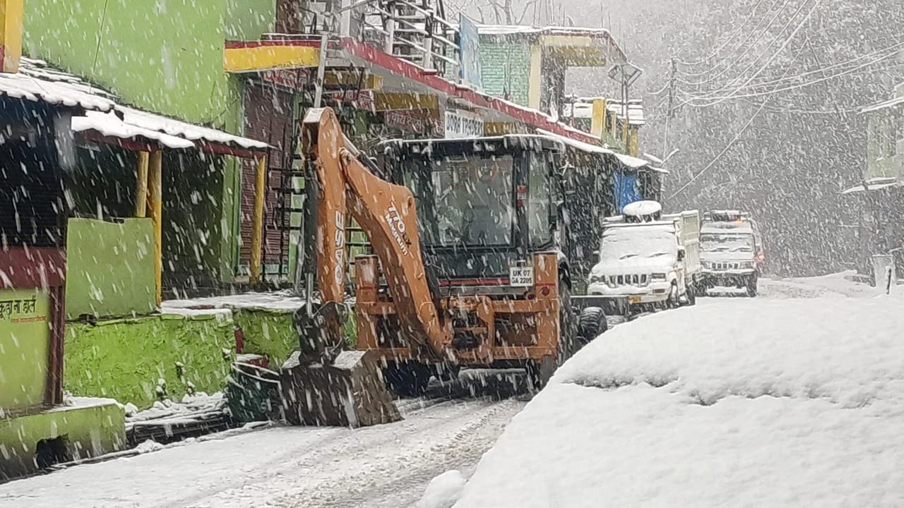 धौलछीना में सड़क से बर्फ हटाती जेसीबी। धौलछीना में सड़क से बर्फ हटाती जेसीबी।
