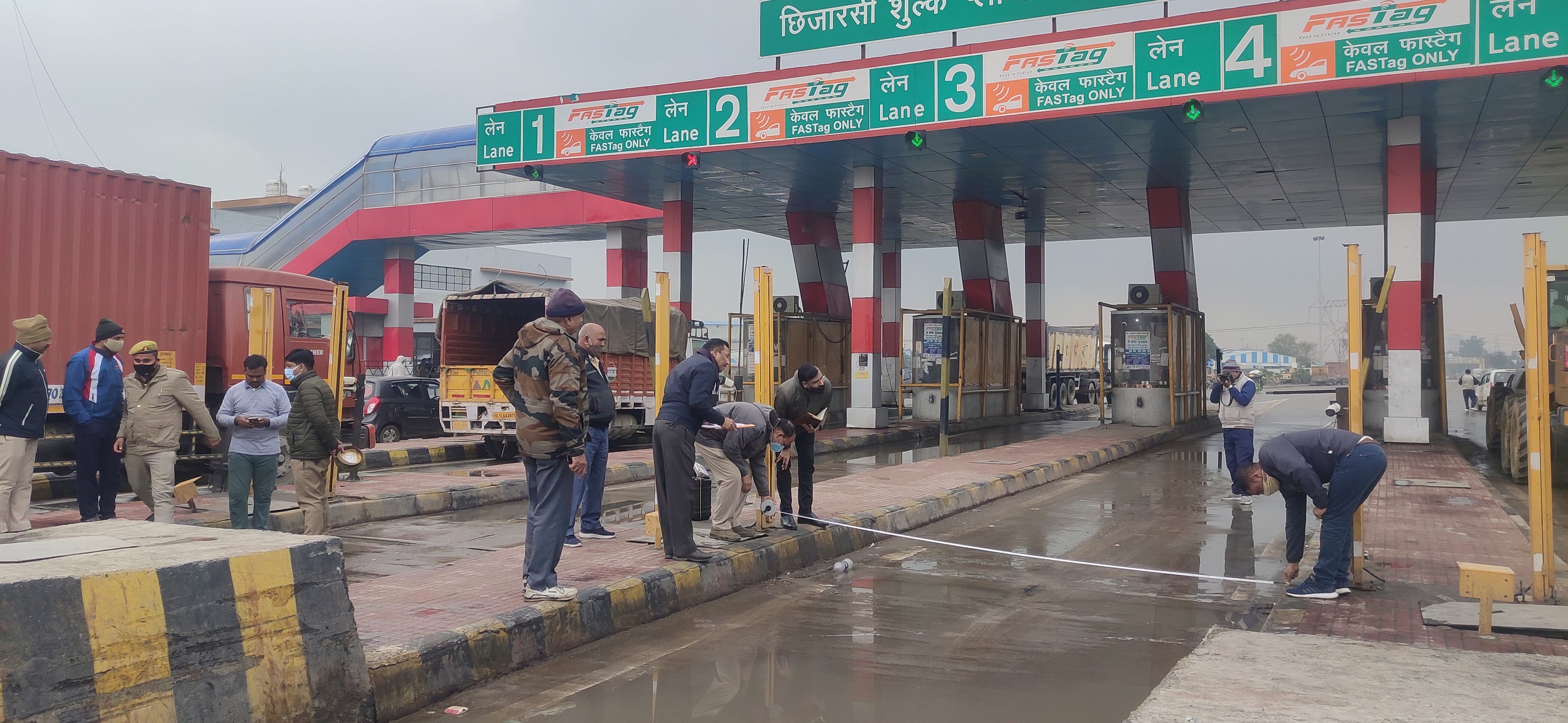 टोल प्लाजा पर हमले वाले स्थान पर नाप-तोल करते विधि विज्ञान प्रयोगशाला की टीम।