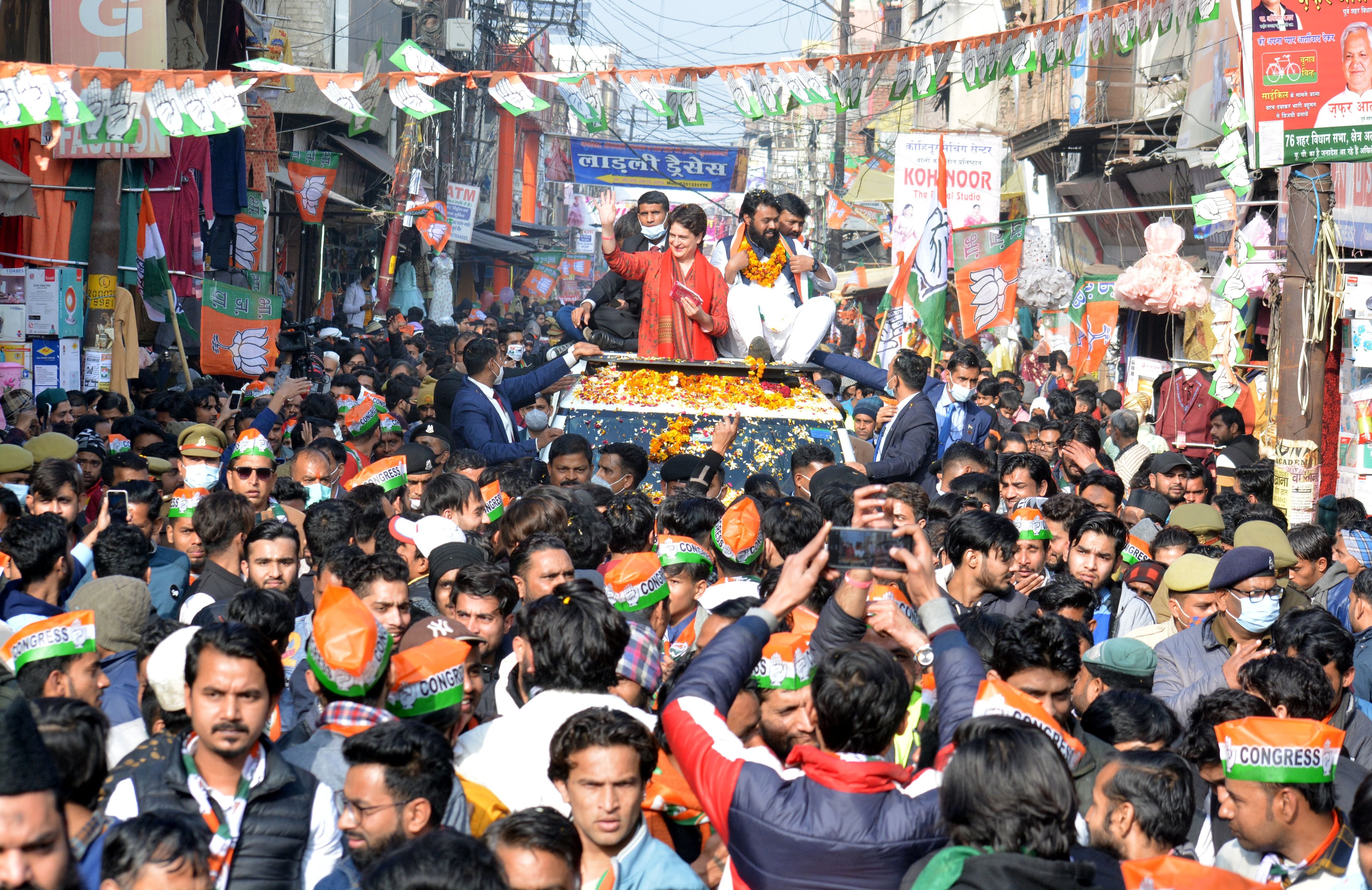 रोड शो के दौरान हाथ उठाकर लोगों का अभिवादन करतीं प्रियंका गांधी।