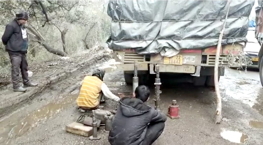 बिजनौर में बैराज रोड पर खराब हुए वाहनों को सही करते ड्राइवर। बिजनौर में बैराज रोड पर खराब हुए वाहनों को सही करते ड्राइवर।