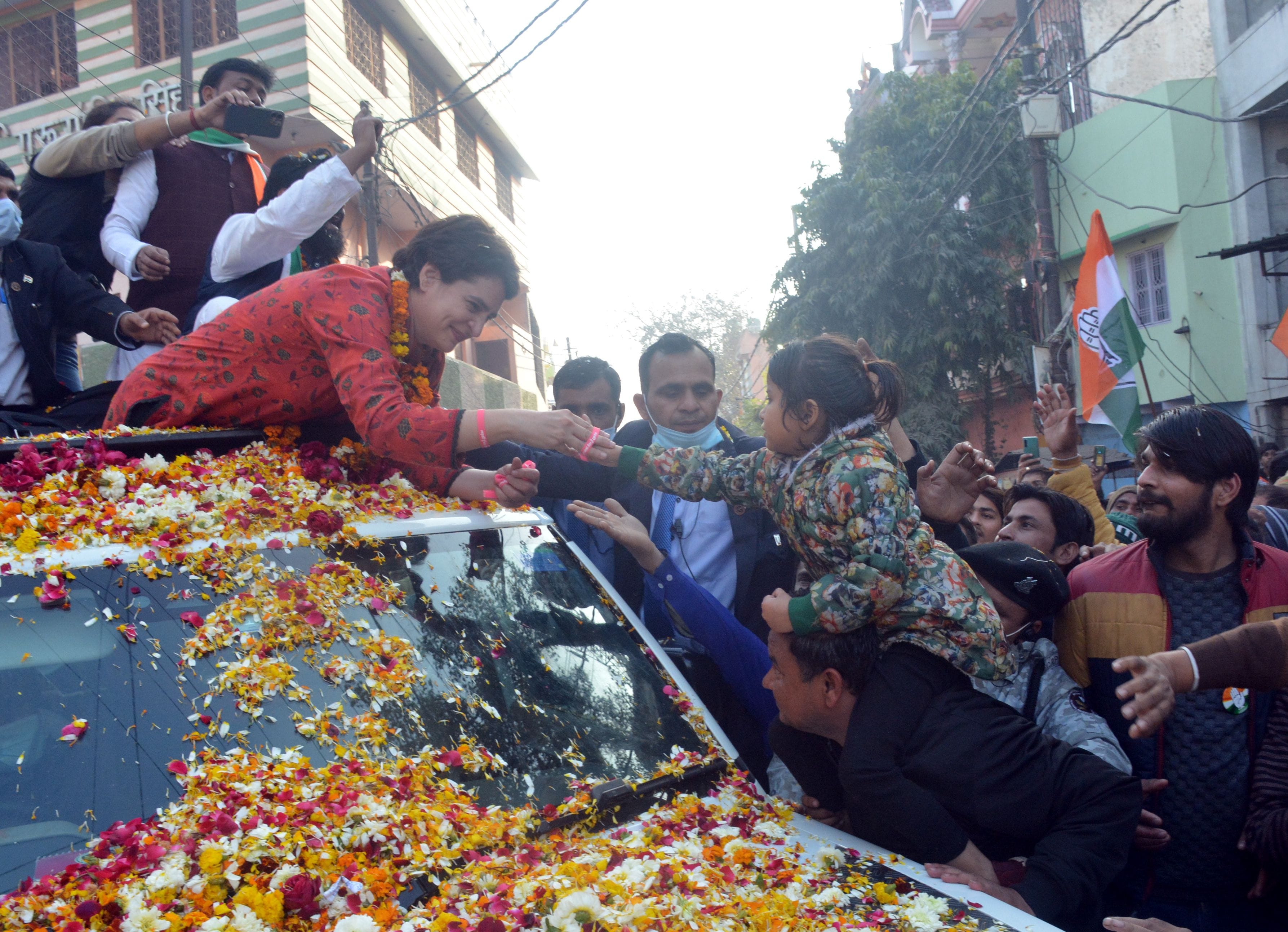 रोड शो के दौरान देहलीगेट में बच्ची के हाथ में बंधा पहनाती प्रियंका गांधी । 