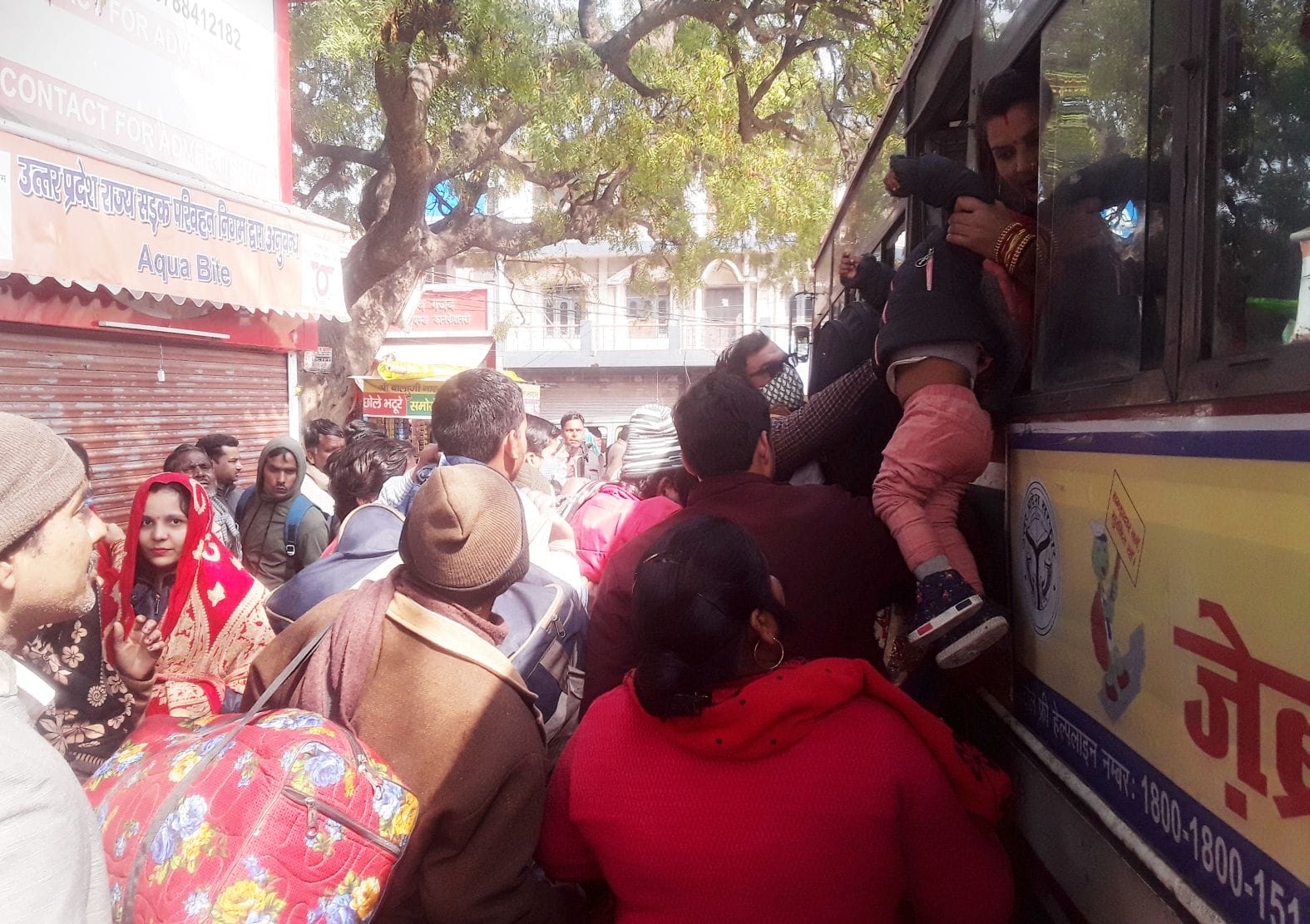 बच्चे को खिड़की से बस के अंदर करवाने का प्रयास करती महिला यात्री। संवाद बच्चे को खिड़की से बस के अंदर करवाने का प्रयास करती महिला यात्री। संवाद
